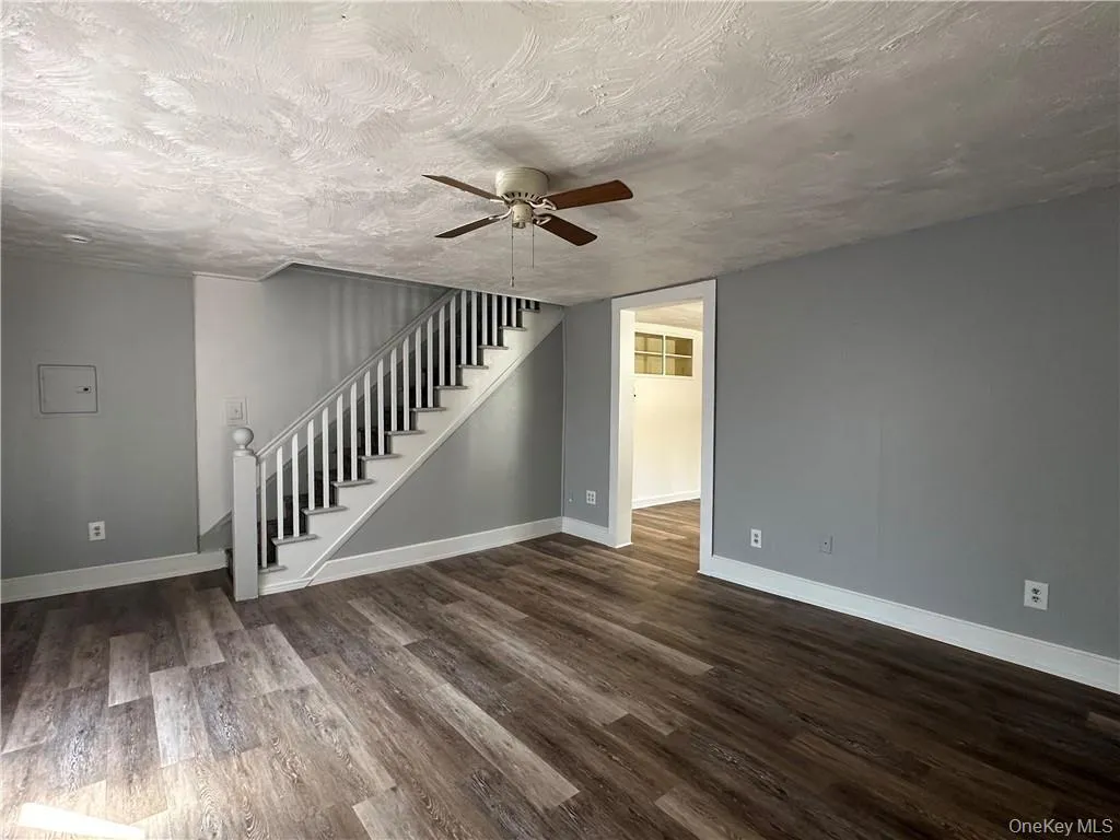 Spare room with ceiling fan, a textured ceiling, and dark hardwood / wood-style floors Spare room with ceiling fan, a textured ceiling, and dark hardwood / wood-style floors