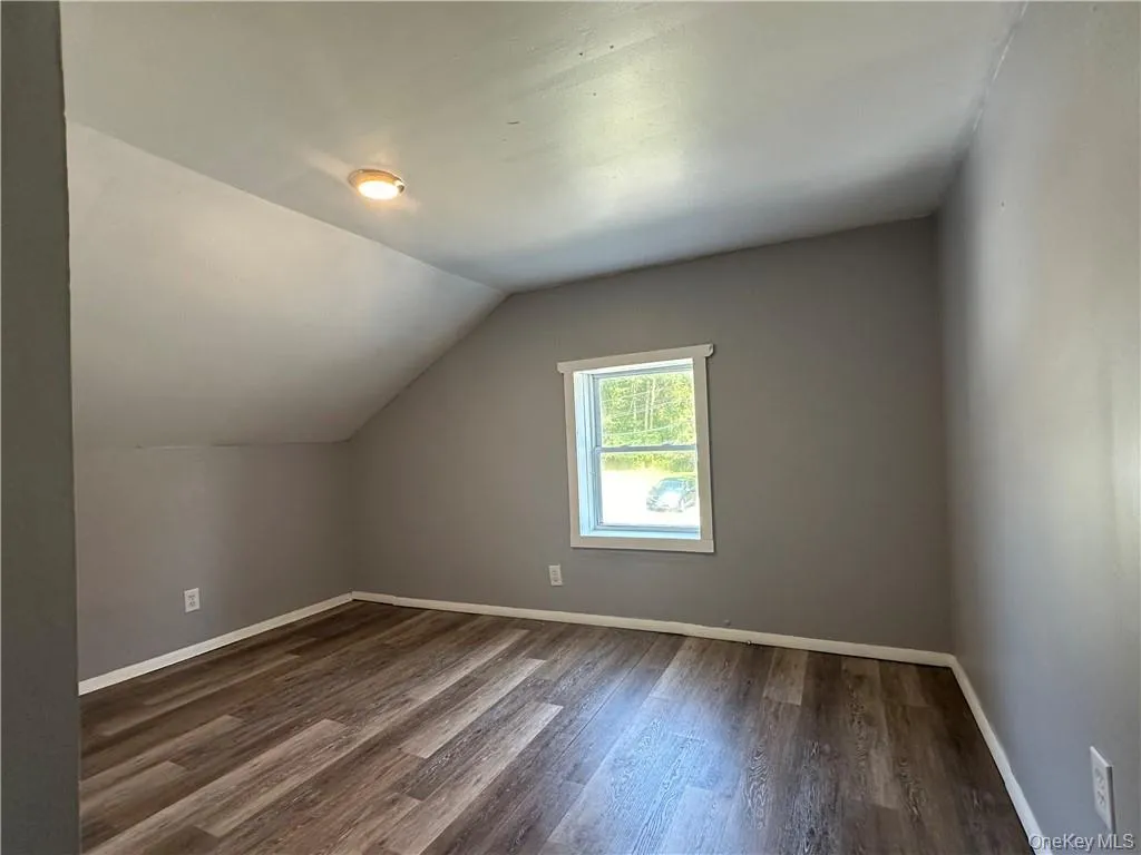 Bonus room with dark hardwood / wood-style floors and vaulted ceiling Bonus room with dark hardwood / wood-style floors and vaulted ceiling