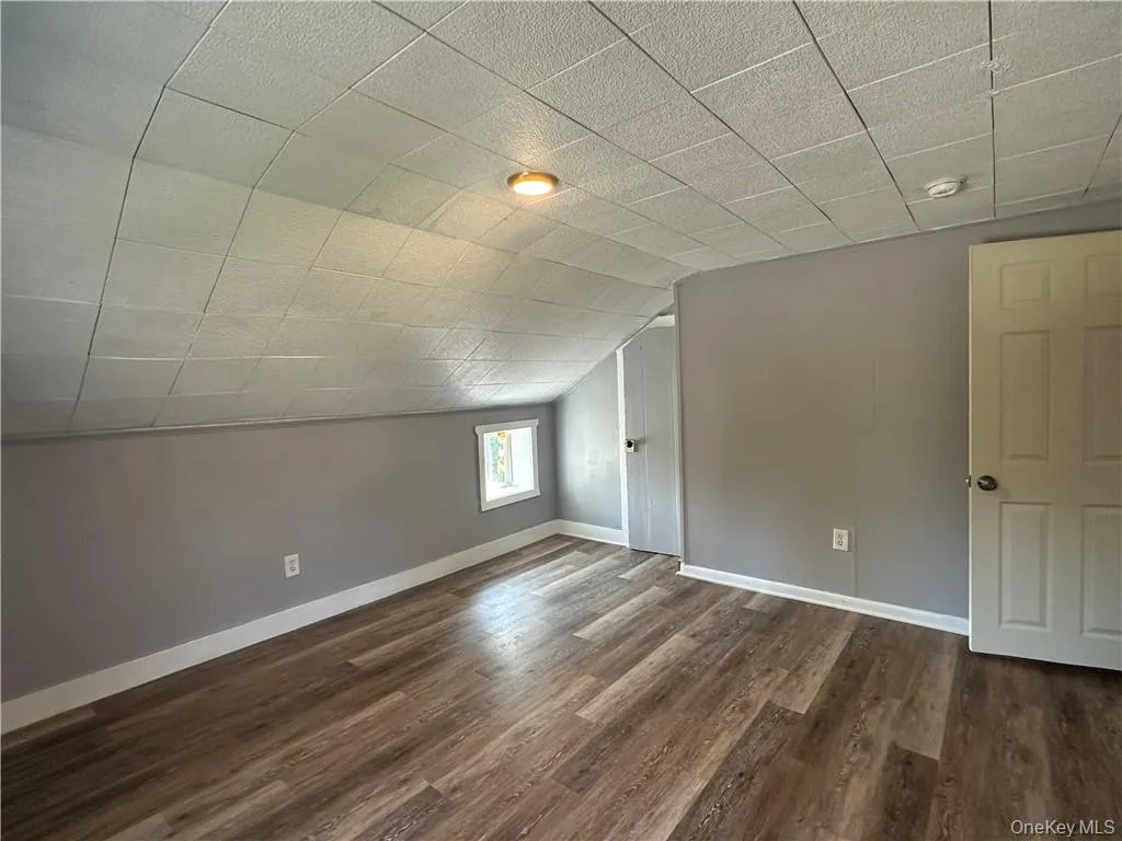 Additional living space featuring lofted ceiling and dark hardwood / wood-style flooring Additional living space featuring lofted ceiling and dark hardwood / wood-style flooring