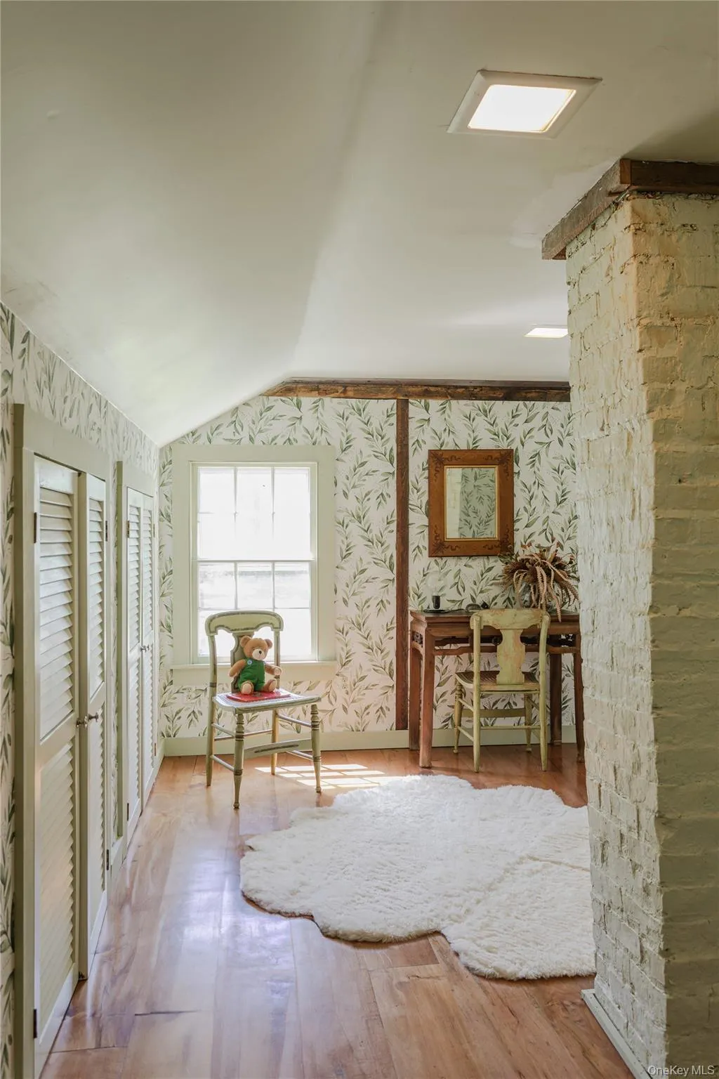 Bedroom featuring wood-finish flooring, a pitched ceiling Bedroom featuring wood-finish flooring, a pitched ceiling