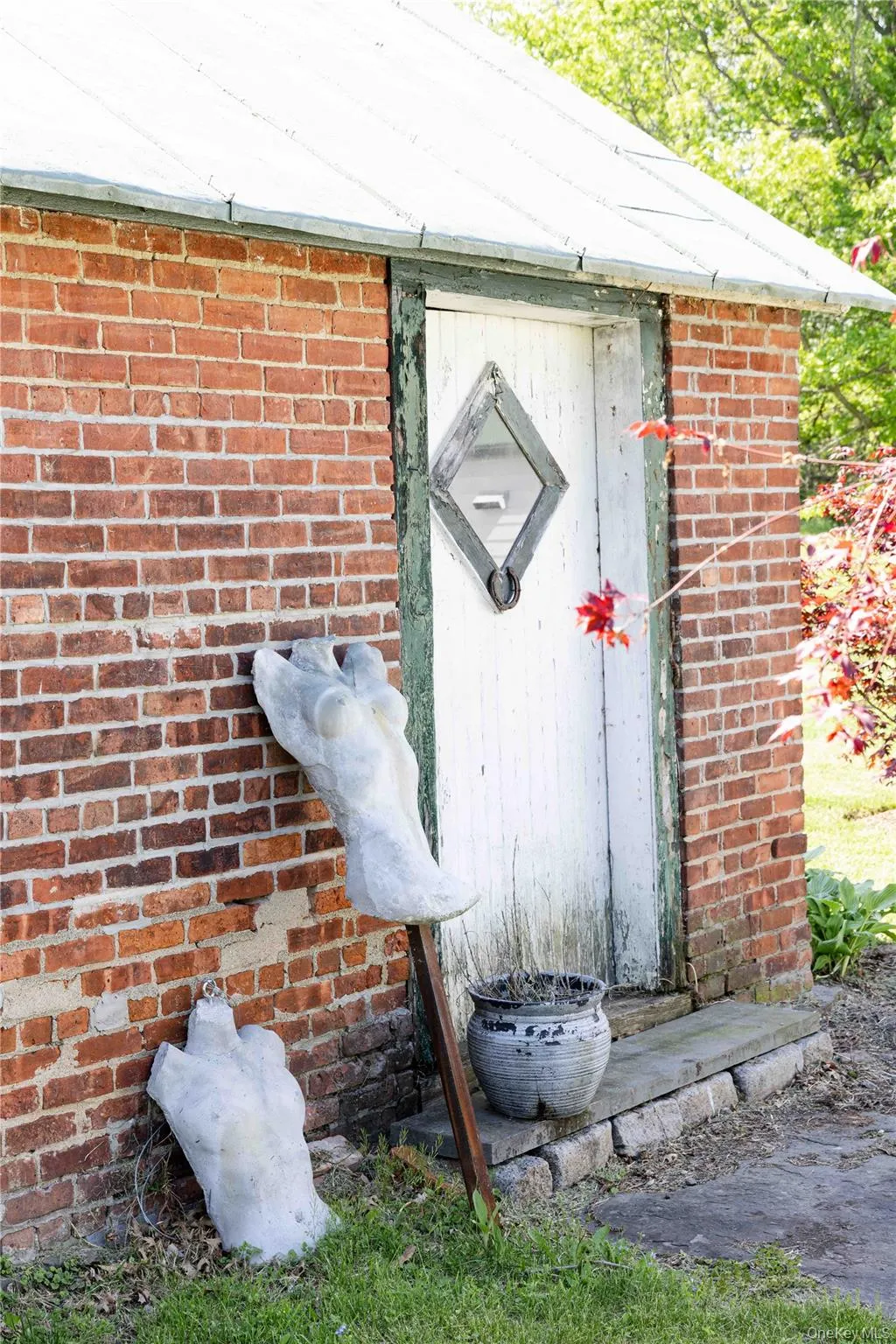 Brick storage exterior structure featuring a white wooden door with a diamond-shaped window Brick storage exterior structure featuring a white wooden door with a diamond-shaped window