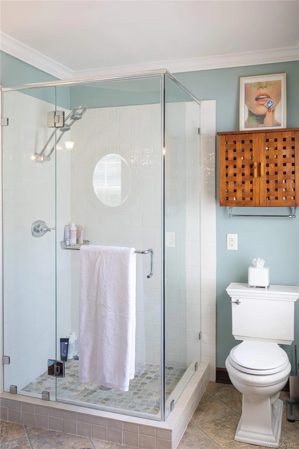 Glass-enclosed shower with white vertical subway tile, a built-in shelf, and a mosaic tile floor Glass-enclosed shower with white vertical subway tile, a built-in shelf, and a mosaic tile floor