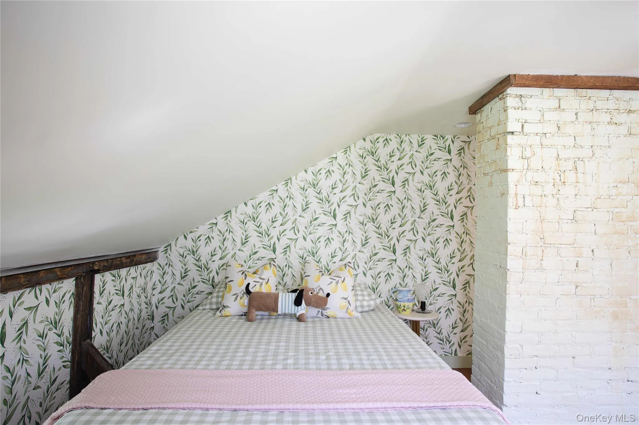 Bedroom featuring an angled ceiling and exposed wooden structural beams Bedroom featuring an angled ceiling and exposed wooden structural beams