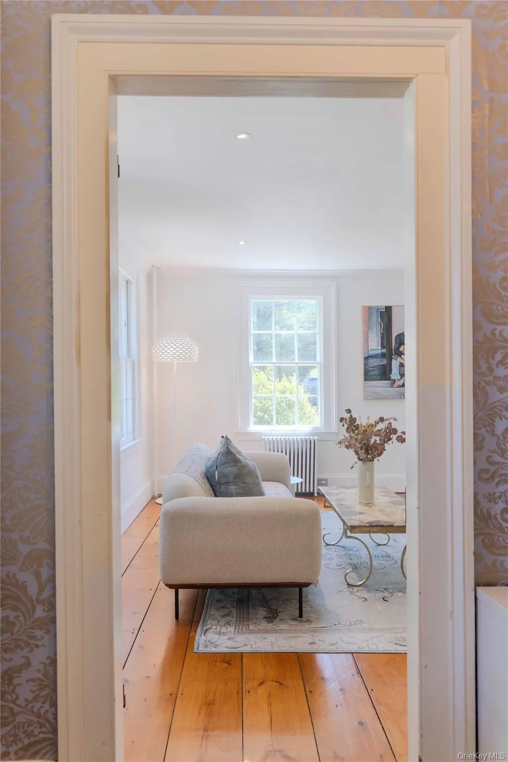 Room entry with decorative trim framing, featuring light wood-finish flooring extending into the interior space Room entry with decorative trim framing, featuring light wood-finish flooring extending into the interior space