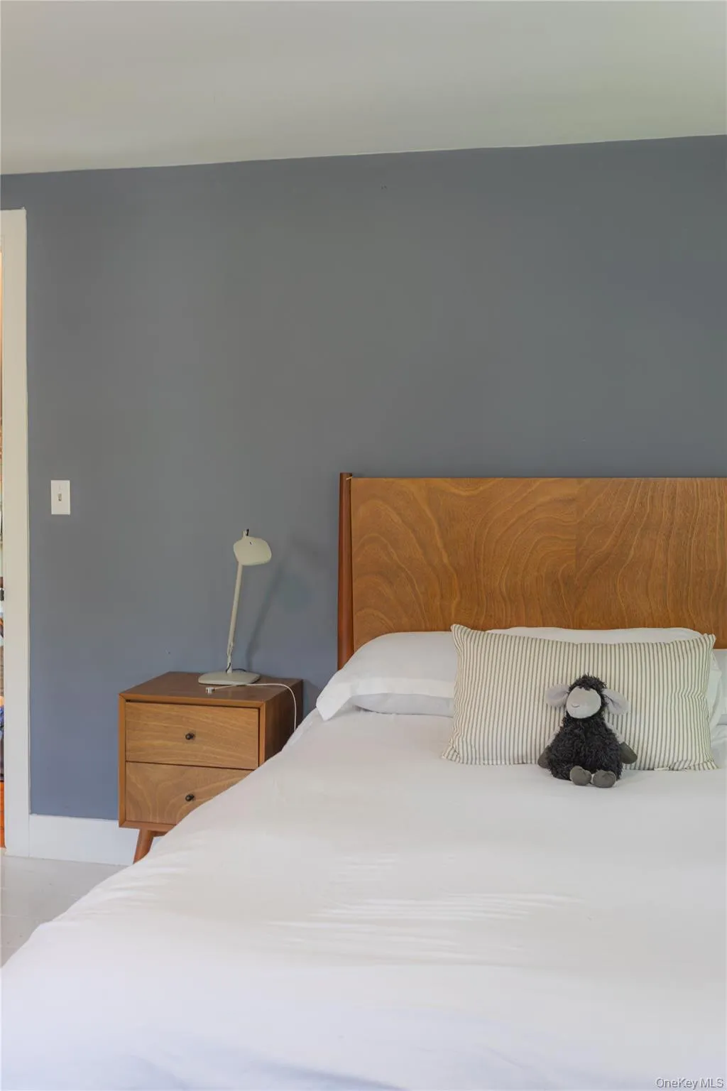 Primary Bedroom featuring a Queen size wood-finish headboard, painted walls, and wood-finish nightstand with two drawers Primary Bedroom featuring a Queen size wood-finish headboard, painted walls, and wood-finish nightstand with two drawers