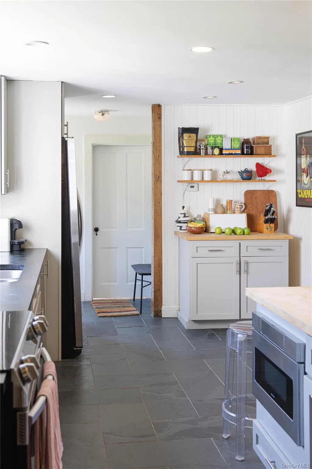 Kitchen with slate tile flooring, recessed lighting, and white shiplap wall paneling Kitchen with slate tile flooring, recessed lighting, and white shiplap wall paneling