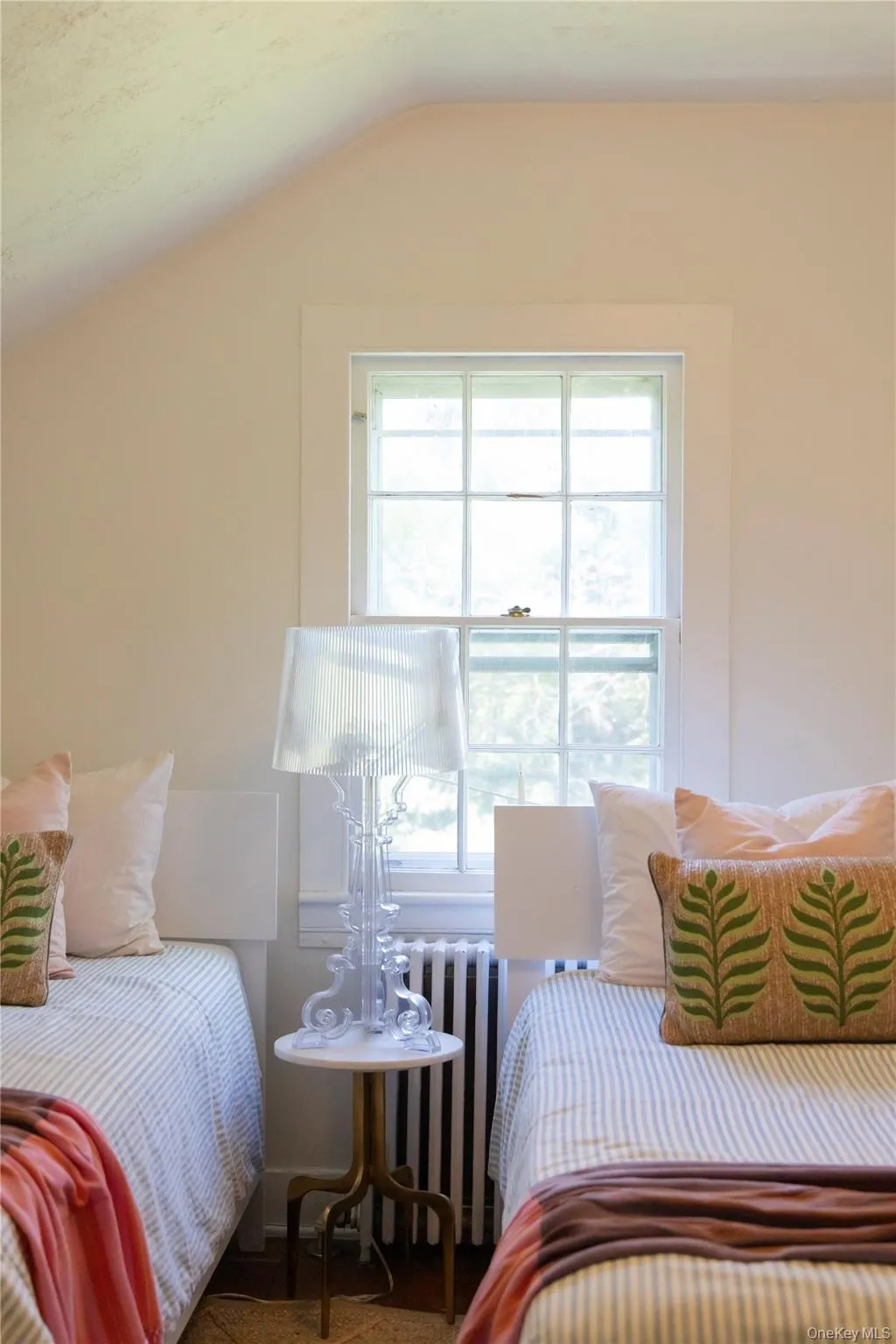 Bedroom featuring a single-pane window, white window trim, and a sloped ceiling Bedroom featuring a single-pane window, white window trim, and a sloped ceiling