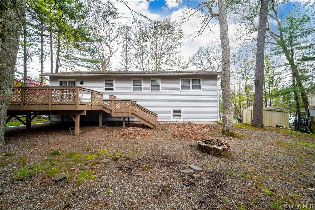 The rear of the home features an elevated wooden deck enclosed by a lattice railing. The rear of the home features an elevated wooden deck enclosed by a lattice railing.