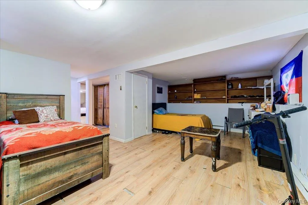 Spacious interior room featuring light wood-finish flooring, recessed lighting, and white walls Spacious interior room featuring light wood-finish flooring, recessed lighting, and white walls