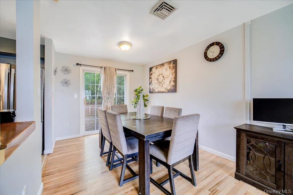 Dining area featuring wood-finish flooring and a ceiling-mounted light fixture Dining area featuring wood-finish flooring and a ceiling-mounted light fixture