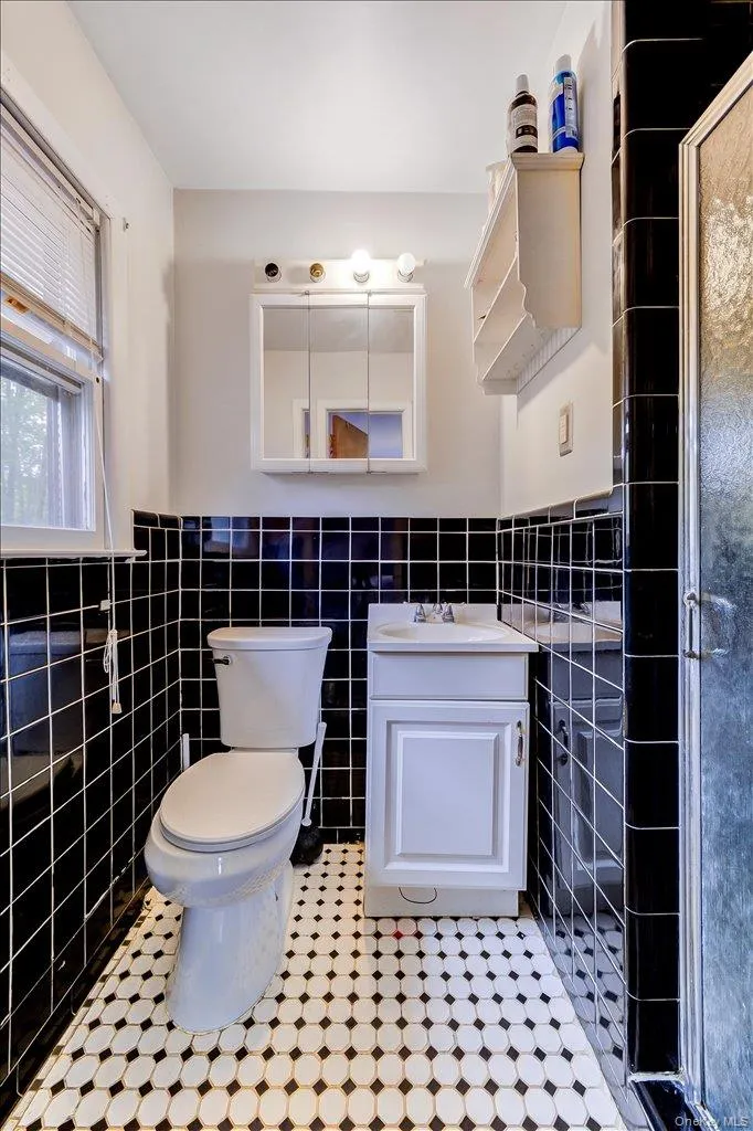 Primary Bathroom featuring black subway tile walls and white and black patterned floor tile Primary Bathroom featuring black subway tile walls and white and black patterned floor tile