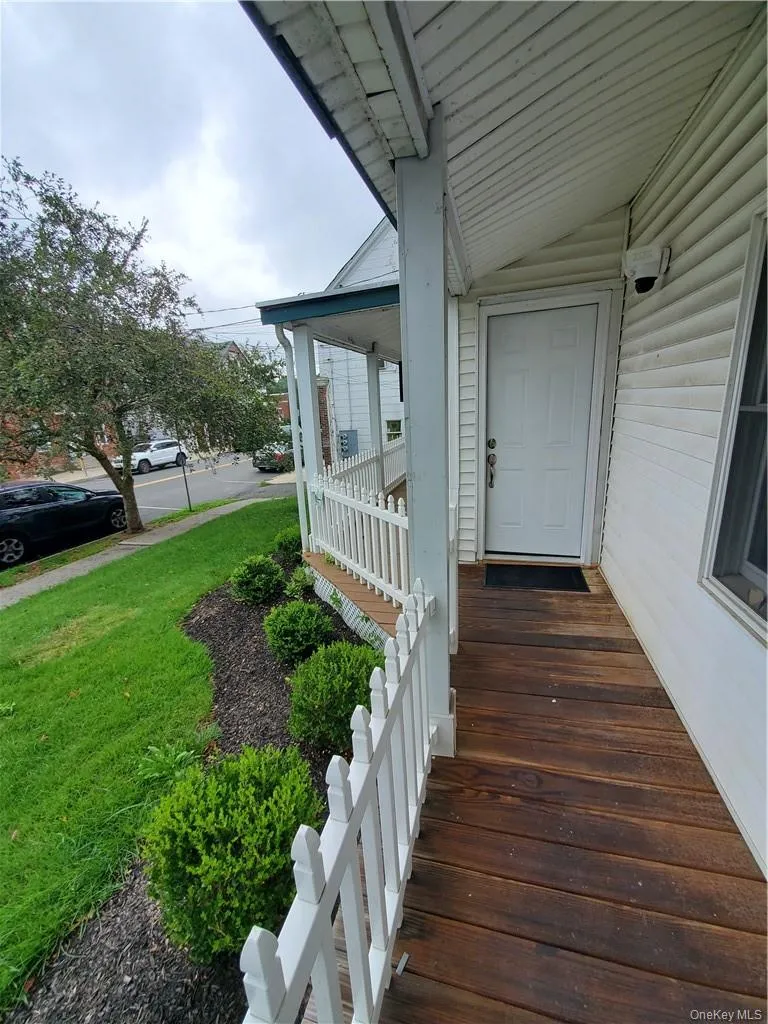 Property entrance with covered porch and a yard Property entrance with covered porch and a yard