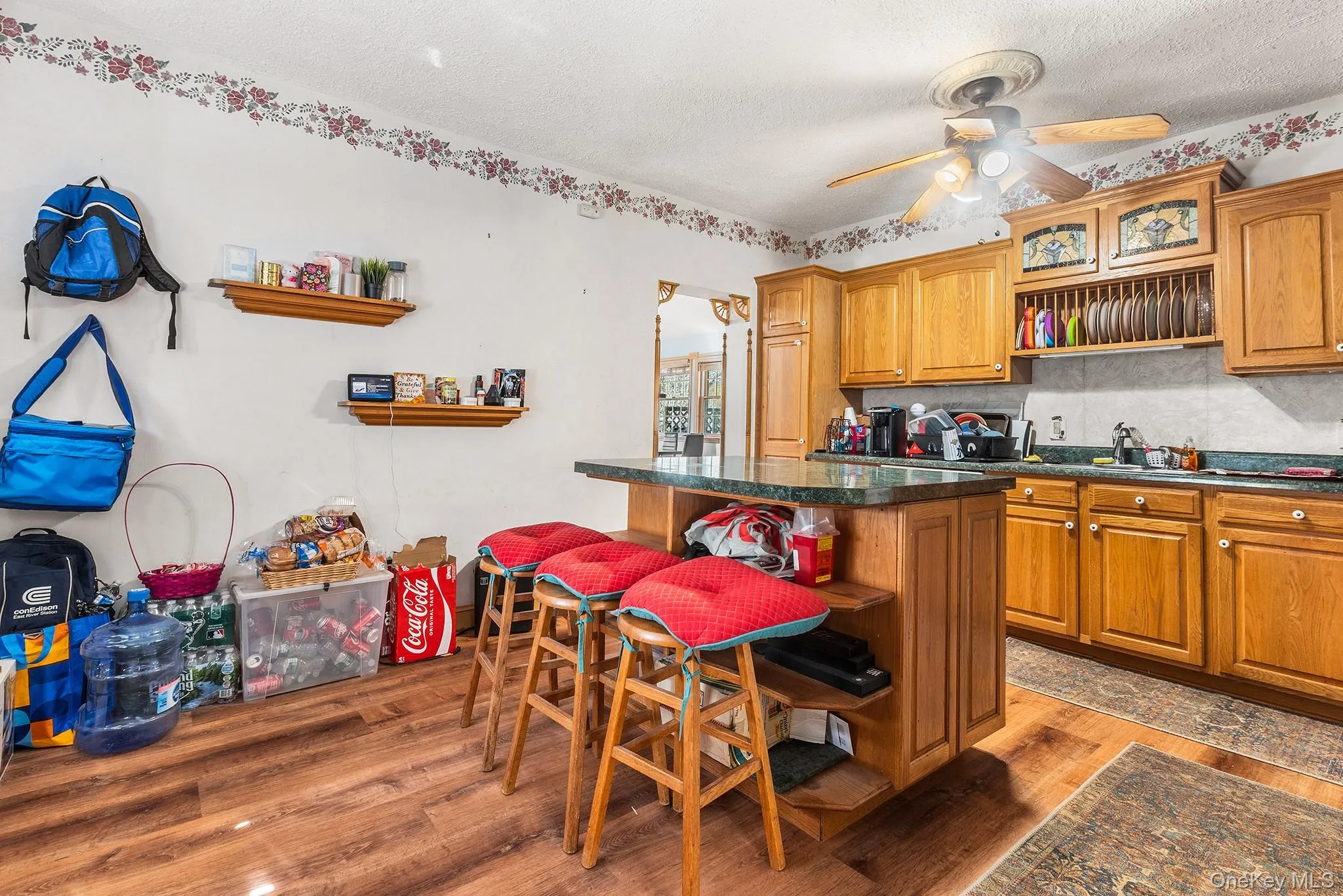 Kitchen featuring wood-finish flooring and a central island with a countertop Kitchen featuring wood-finish flooring and a central island with a countertop
