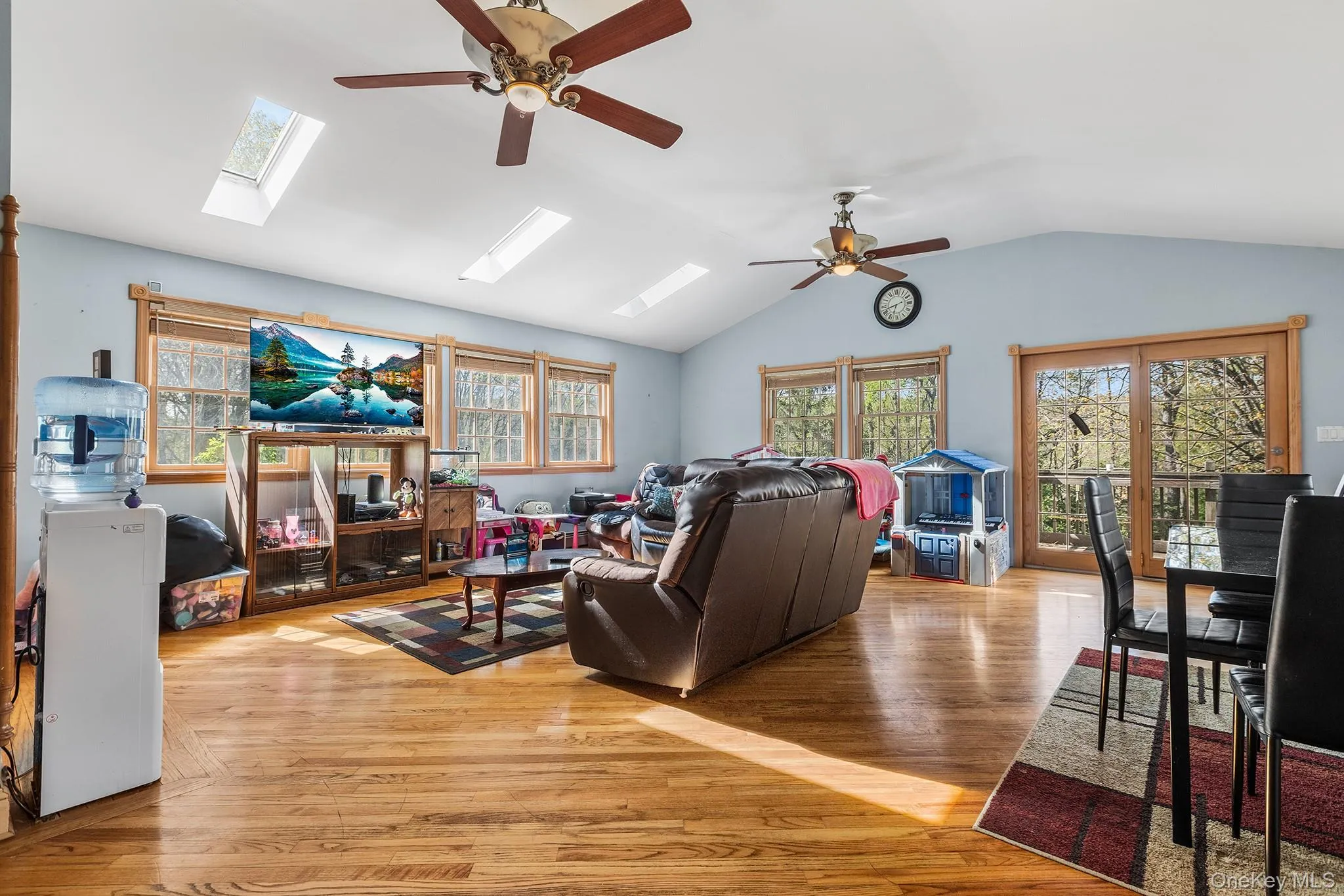 Expansive open-concept room featuring wood-finish flooring and a vaulted ceiling Expansive open-concept room featuring wood-finish flooring and a vaulted ceiling