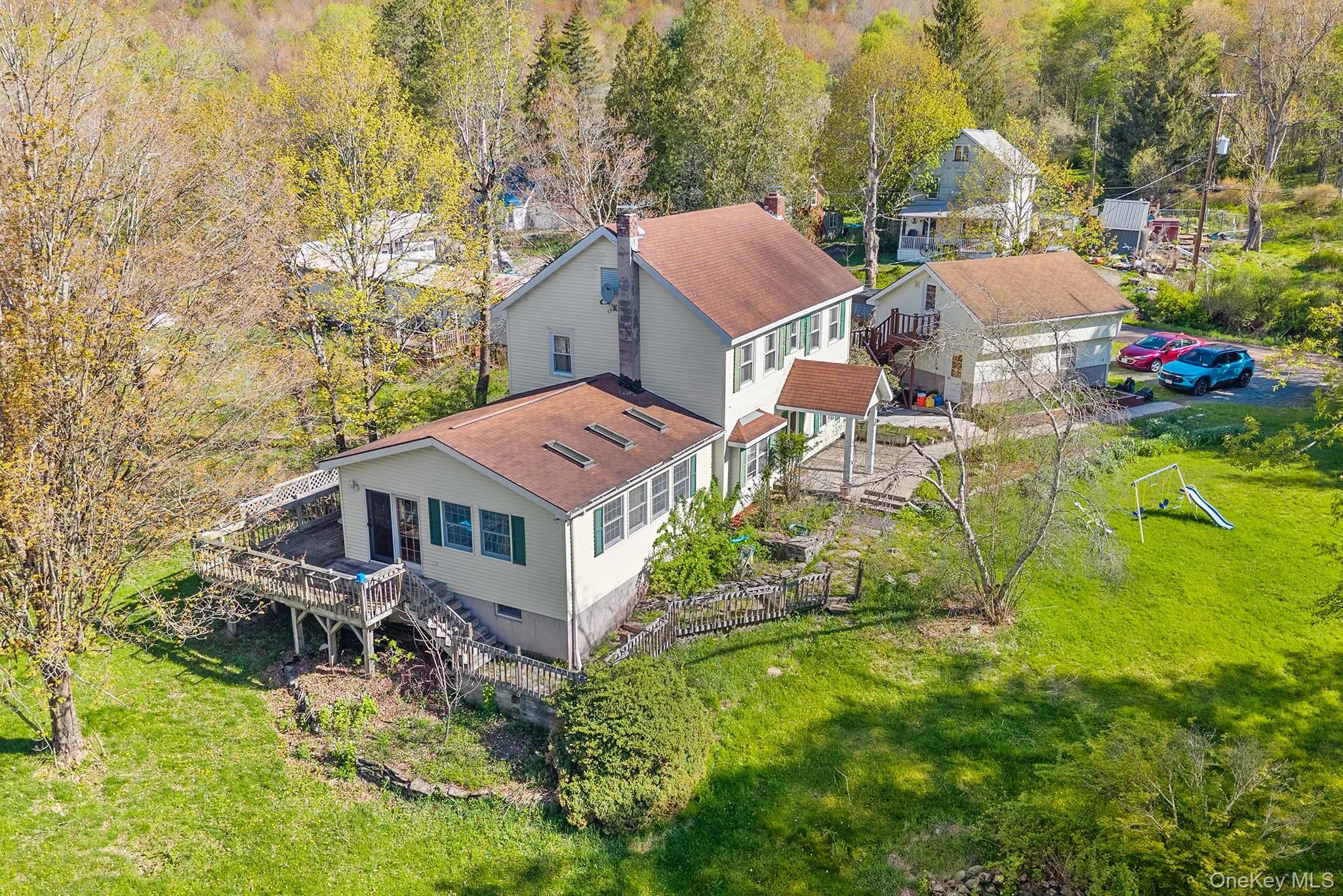 Expansive property featuring a multi-level residence with a large rear deck and an attached porch Expansive property featuring a multi-level residence with a large rear deck and an attached porch