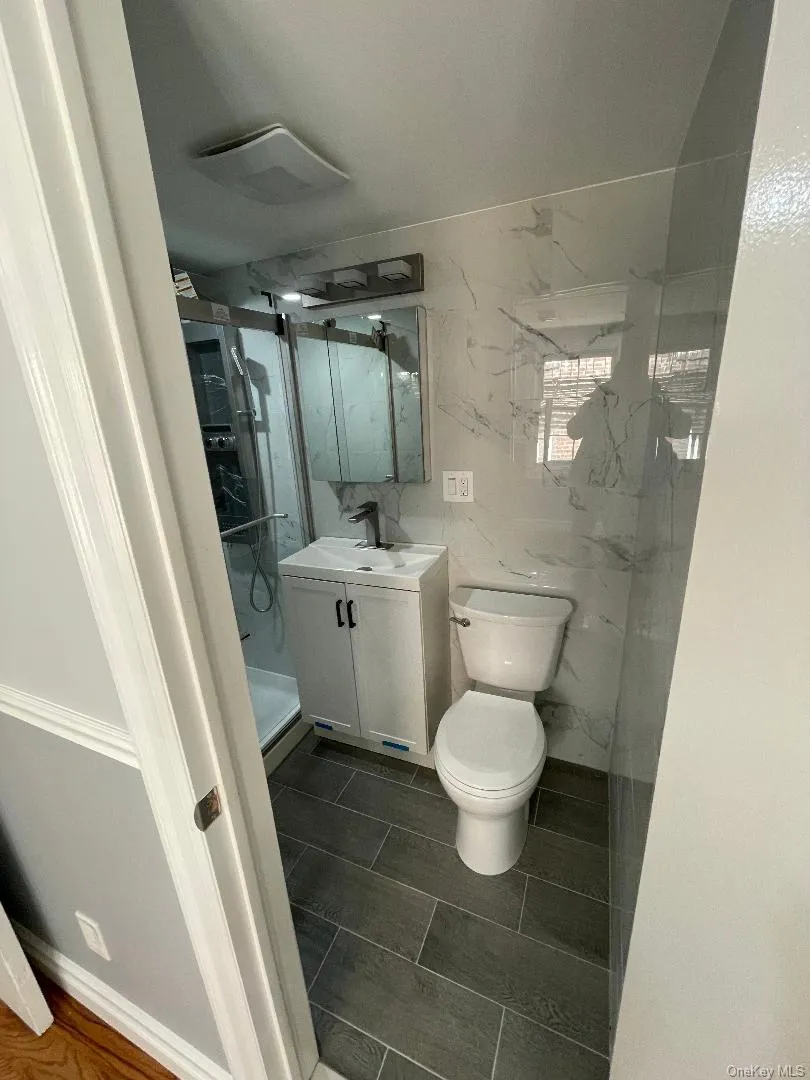 Bathroom with Vanity, Toilet, and Glass Shower Door Bathroom with Vanity, Toilet, and Glass Shower Door