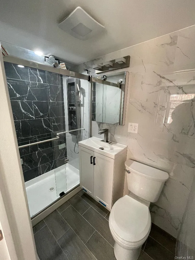 Bathroom with Vanity, Toilet, and Glass Shower Door Bathroom with Vanity, Toilet, and Glass Shower Door