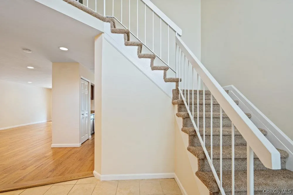 Carpeted staircase featuring white railings and balusters Carpeted staircase featuring white railings and balusters