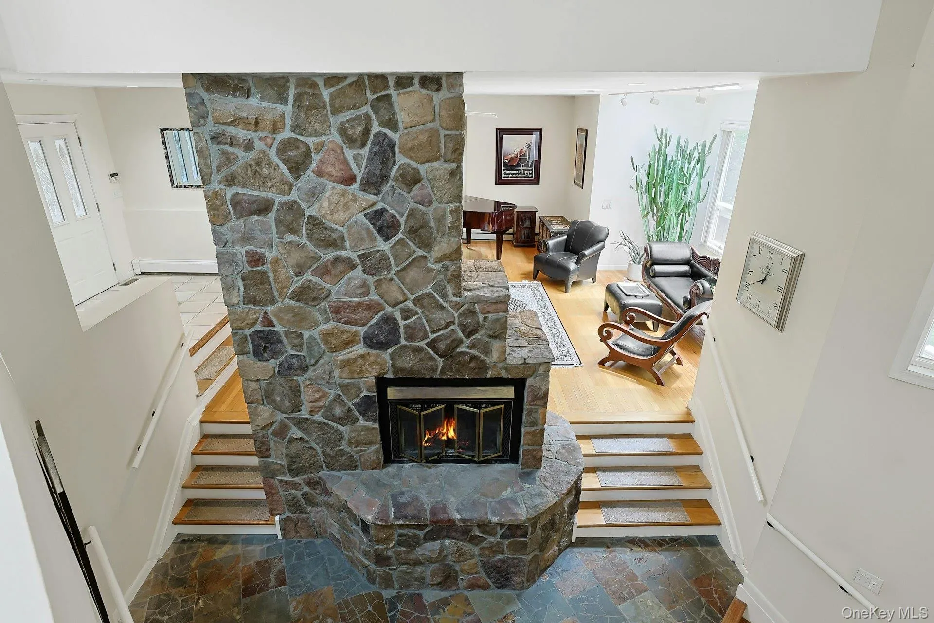 Steps between living room and family separated by stone fireplace Steps between living room and family separated by stone fireplace