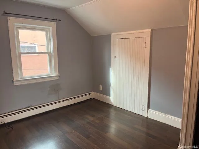 Bonus room with baseboard heating, lofted ceiling, and dark hardwood / wood-style flooring Bonus room with baseboard heating, lofted ceiling, and dark hardwood / wood-style flooring