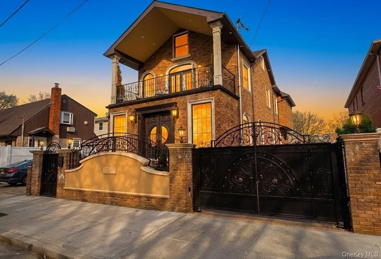 Brick facade residence featuring a grand wrought iron entry gate. A.I Enchanced Brick facade residence featuring a grand wrought iron entry gate. A.I Enchanced