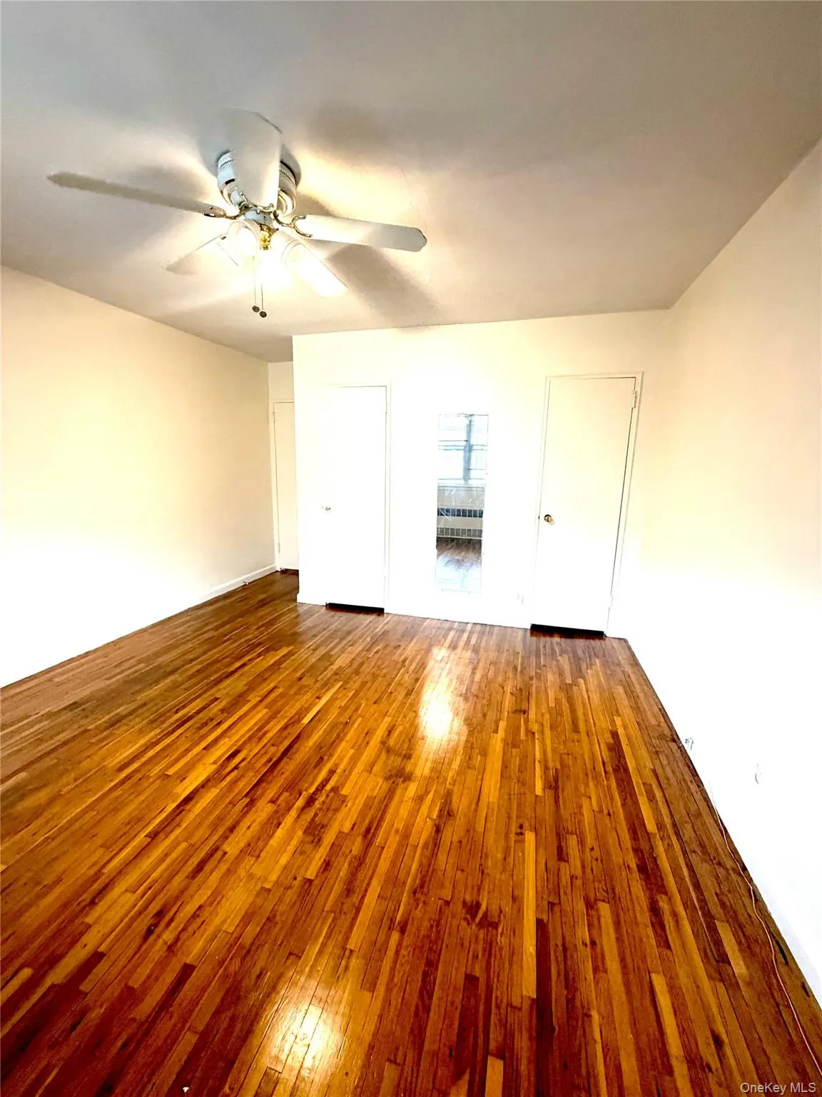 Master Bedroom Refinished wood flooring spans the room, complemented by a ceiling fan with integrated lighting Master Bedroom Refinished wood flooring spans the room, complemented by a ceiling fan with integrated lighting