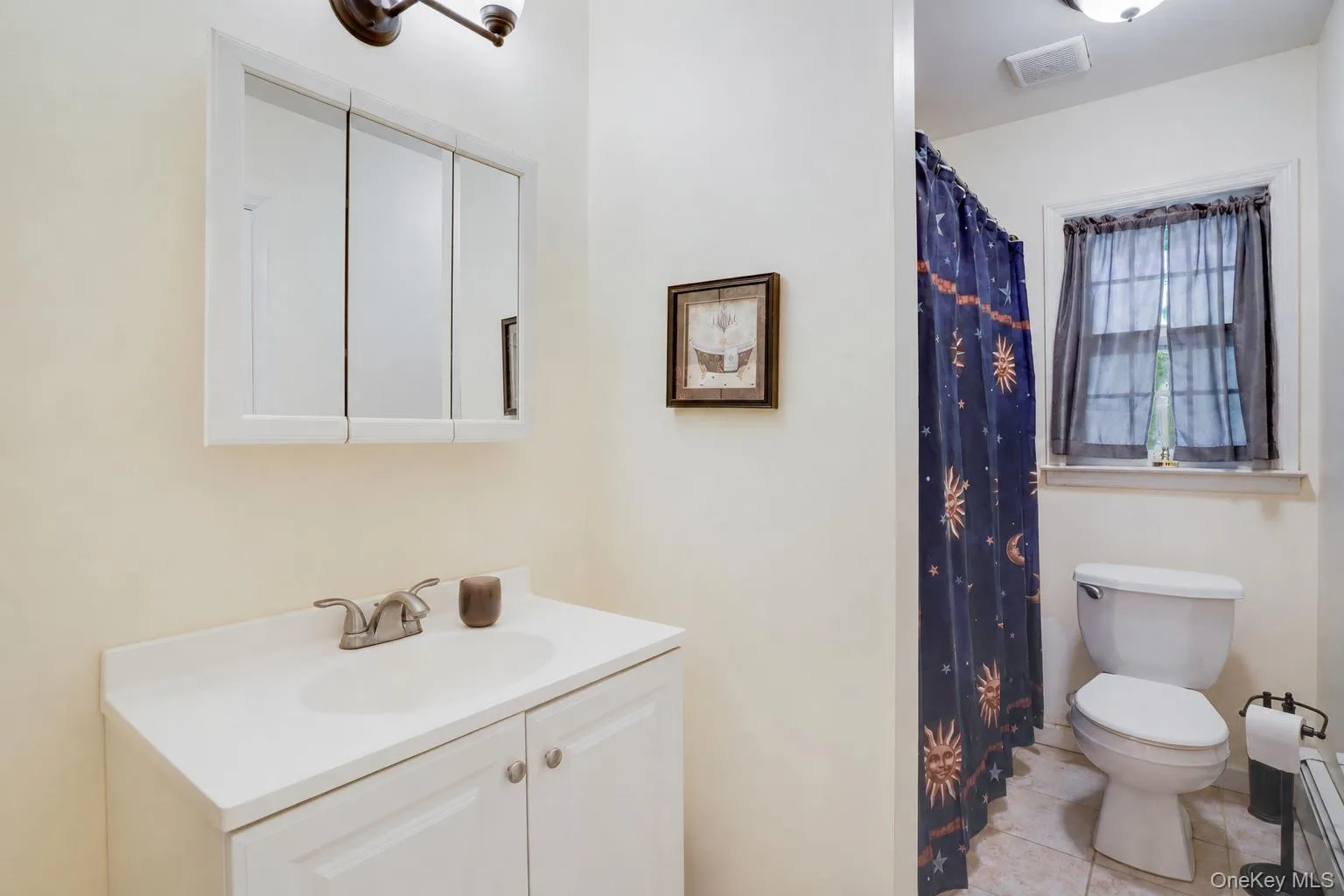 Bathroom vanity featuring a white cabinet, integrated sink, and brushed nickel faucet Bathroom vanity featuring a white cabinet, integrated sink, and brushed nickel faucet