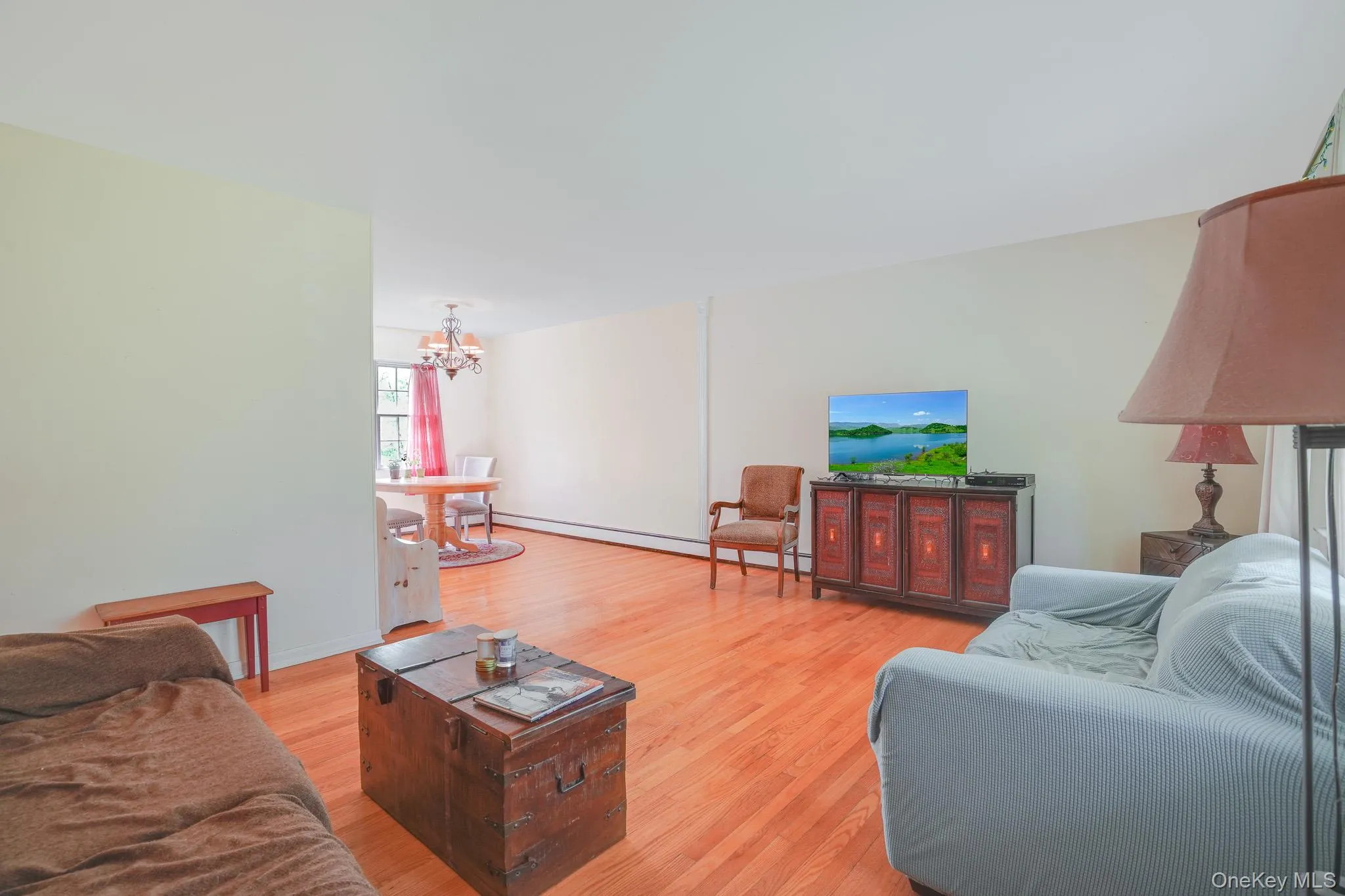 Spacious living area featuring light wood-finish flooring and neutral wall tones Spacious living area featuring light wood-finish flooring and neutral wall tones
