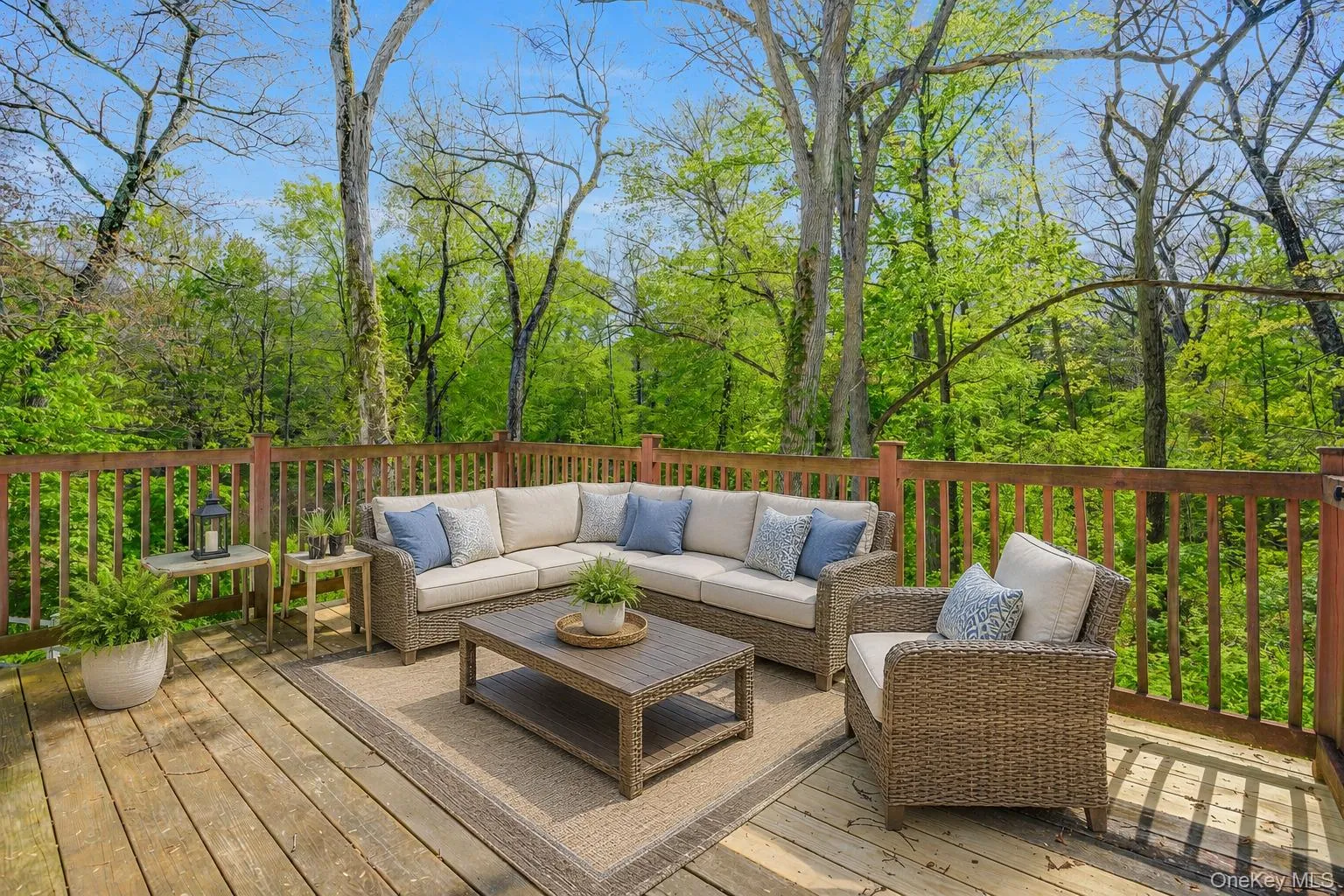Spacious outdoor deck featuring natural wood planks and a wooden railing system, surrounded by mature trees Spacious outdoor deck featuring natural wood planks and a wooden railing system, surrounded by mature trees