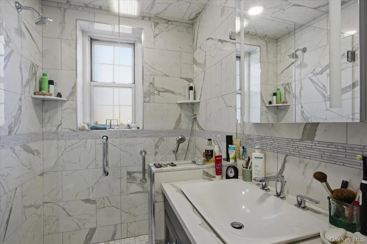 The bathroom is clean and crisp finished with white ceramic tile . The bathroom is clean and crisp finished with white ceramic tile .