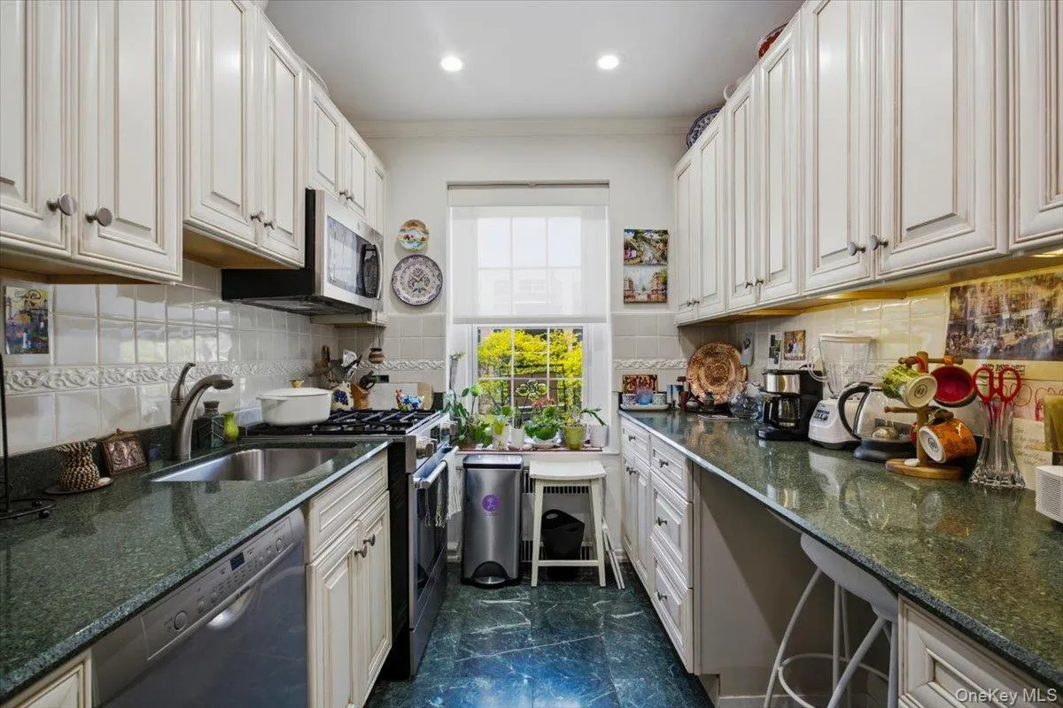 The wide kitchen offers plenty of counter space with granite counters, white cabinets, gas oven & dishwasher. The wide kitchen offers plenty of counter space with granite counters, white cabinets, gas oven & dishwasher.