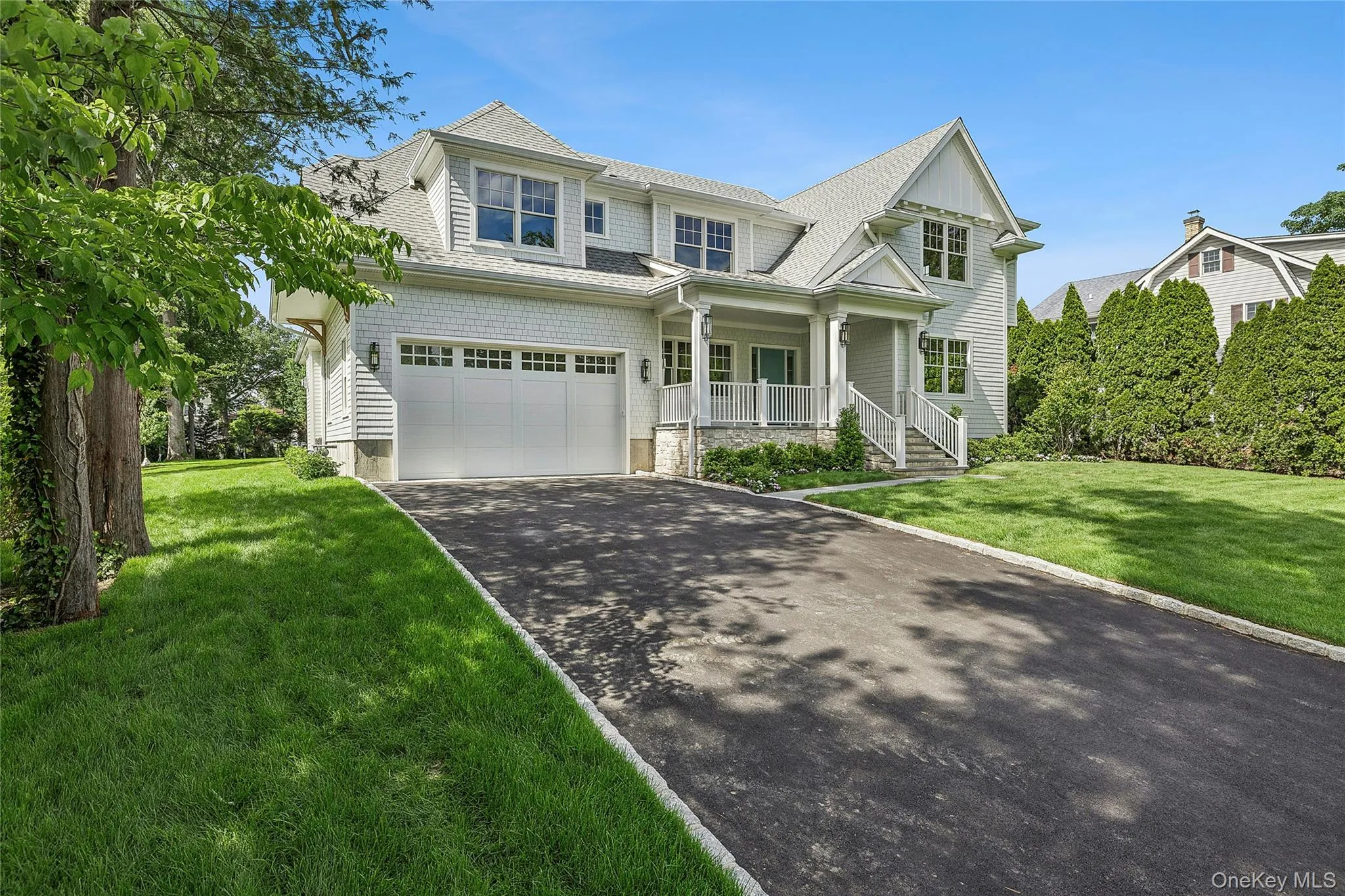 Contemporary residence featuring light gray siding, white trim, and a shingled roof Contemporary residence featuring light gray siding, white trim, and a shingled roof