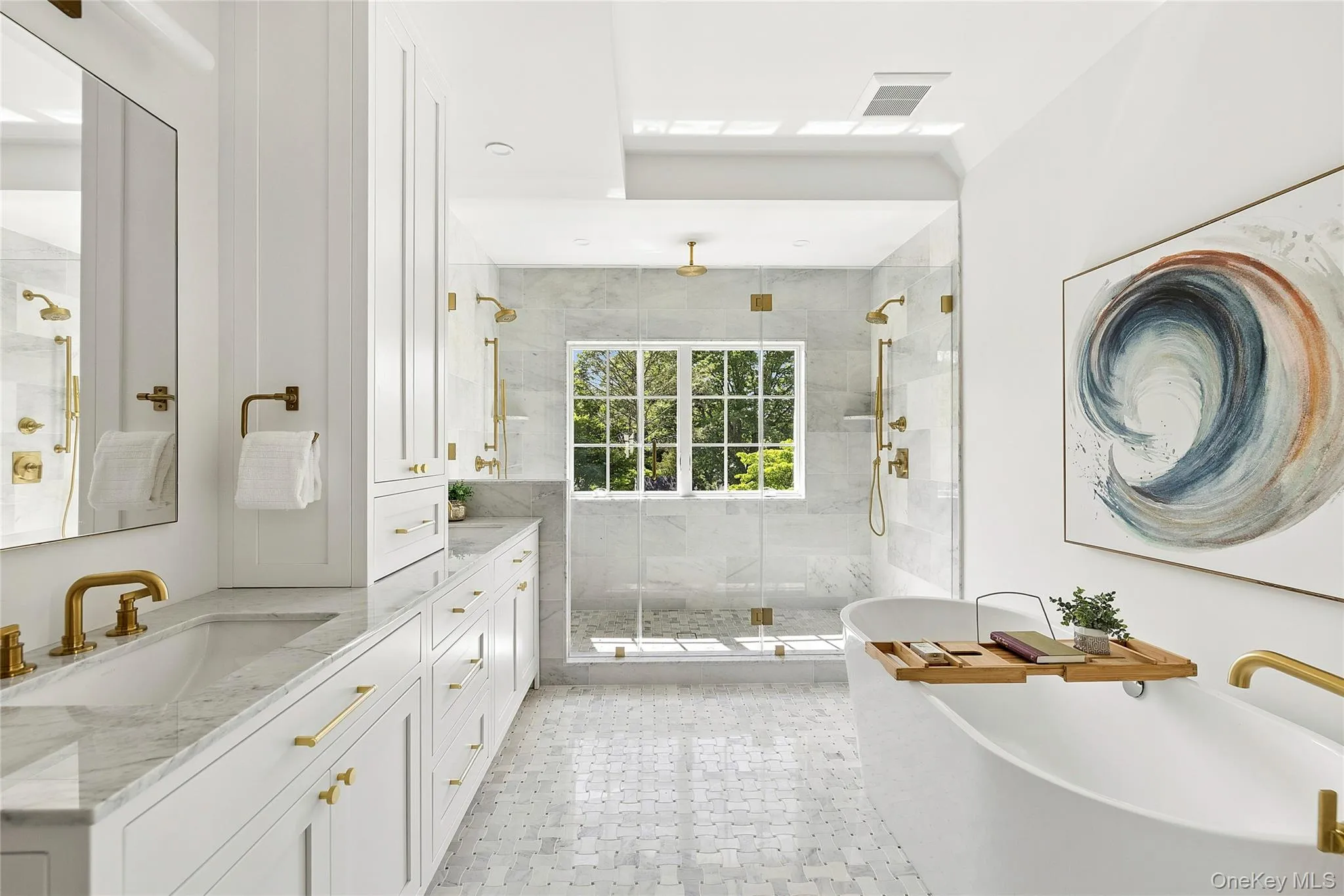 Spacious bathroom featuring a freestanding soaking tub, a large glass-enclosed shower with multiple showerheads, and dual vanity sinks Spacious bathroom featuring a freestanding soaking tub, a large glass-enclosed shower with multiple showerheads, and dual vanity sinks