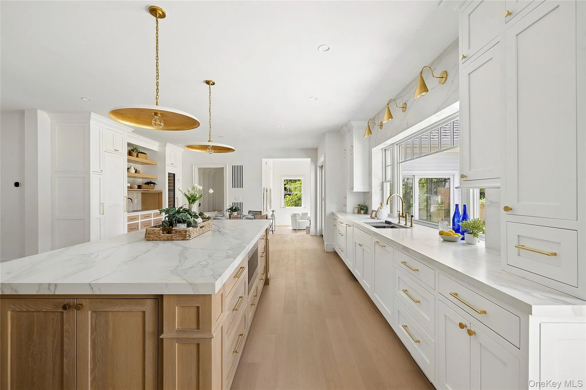 Spacious kitchen featuring a lengthy island with a stone-finish countertop and natural wood-tone cabinetry Spacious kitchen featuring a lengthy island with a stone-finish countertop and natural wood-tone cabinetry