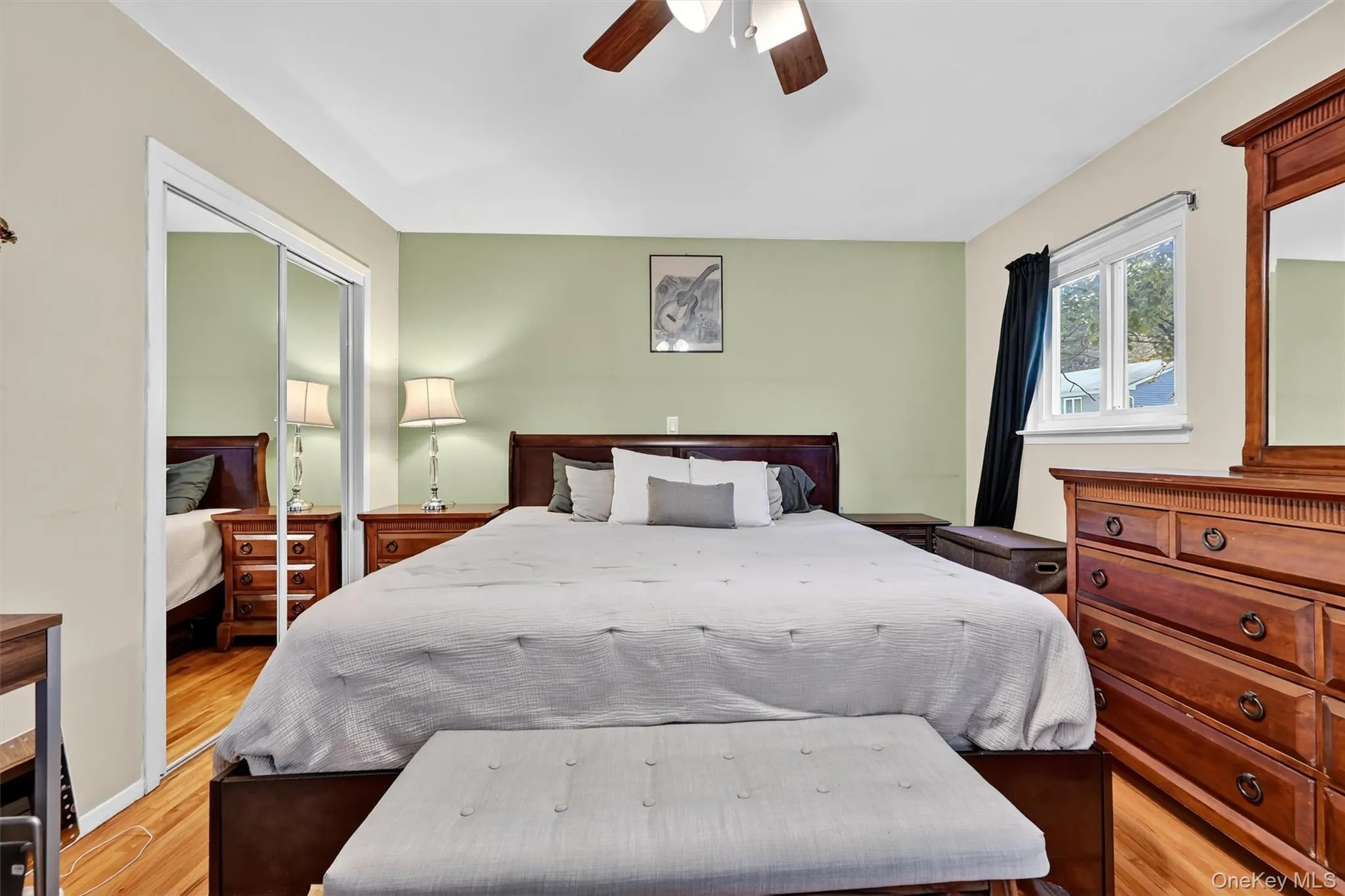 Bedroom featuring light wood-style flooring, a ceiling fan, and a closet Bedroom featuring light wood-style flooring, a ceiling fan, and a closet