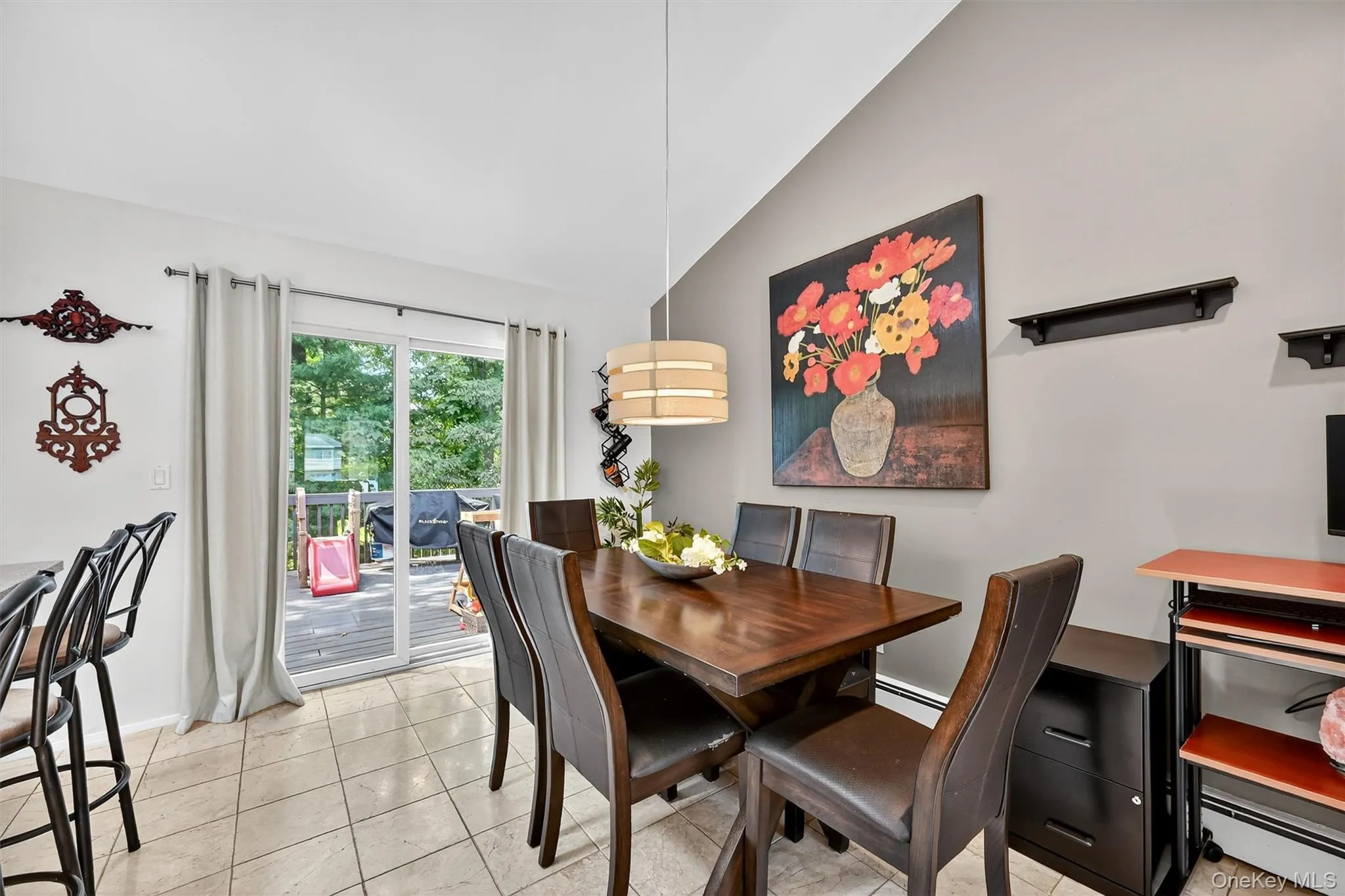 Dining area featuring lofted ceiling, light tile patterned floors, and baseboard heating Dining area featuring lofted ceiling, light tile patterned floors, and baseboard heating