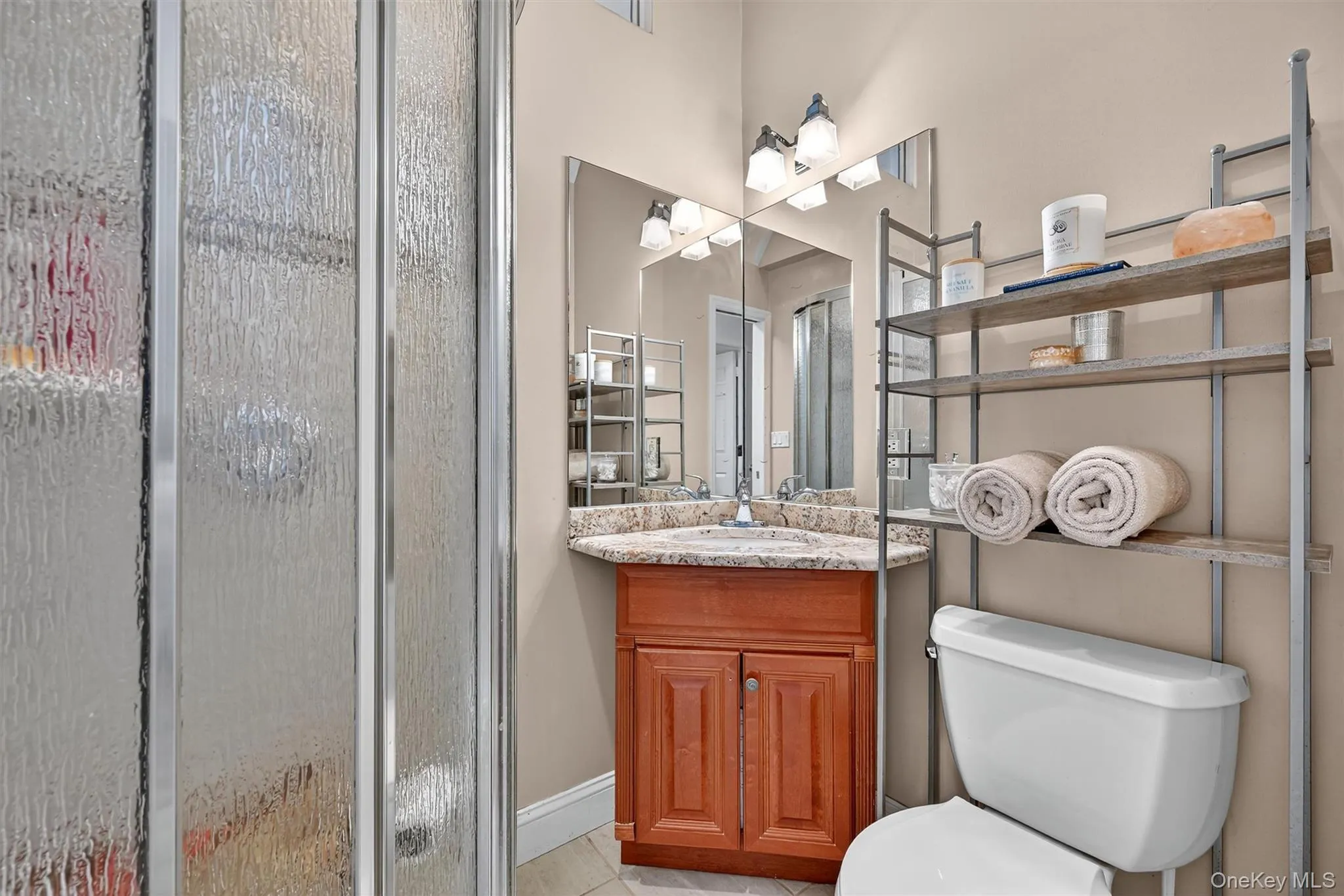 Bathroom with a shower stall, vanity, and light tile patterned floors Bathroom with a shower stall, vanity, and light tile patterned floors