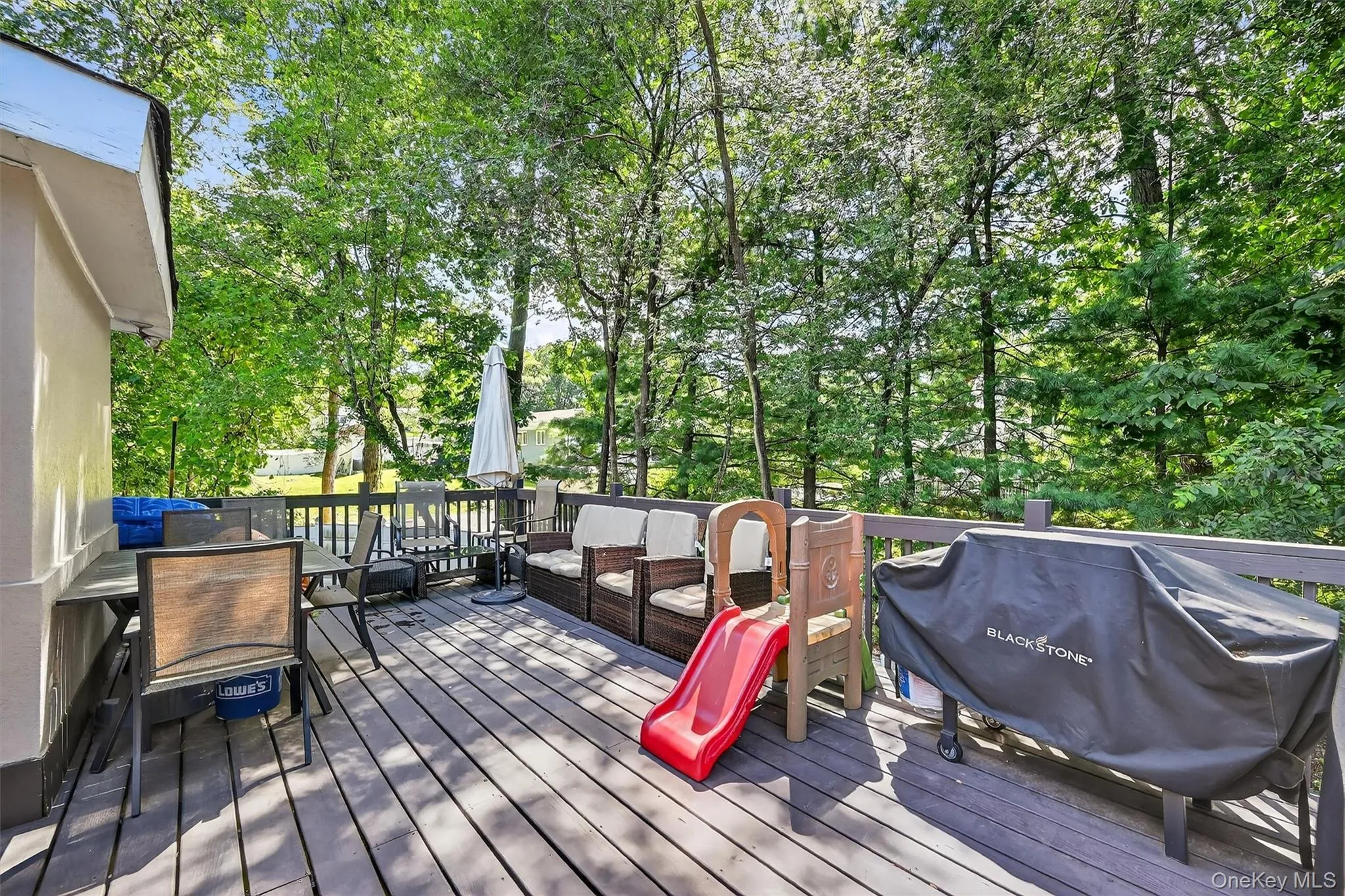 Wooden terrace featuring grilling area, view of wooded area, and outdoor lounge area Wooden terrace featuring grilling area, view of wooded area, and outdoor lounge area