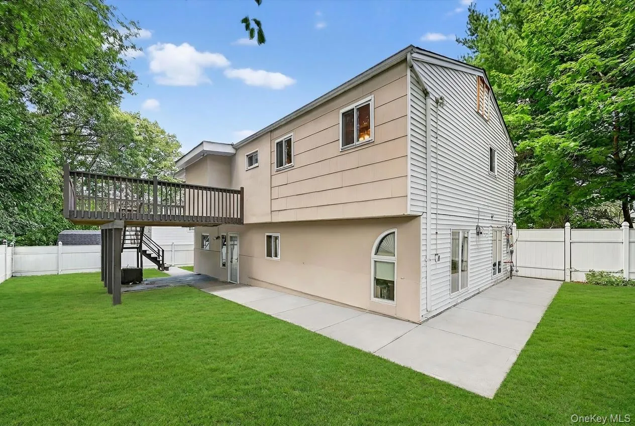 Exterior rear of property featuring a raised wood deck, ground-level patio, multiple entry points, and a private fenced yard Exterior rear of property featuring a raised wood deck, ground-level patio, multiple entry points, and a private fenced yard