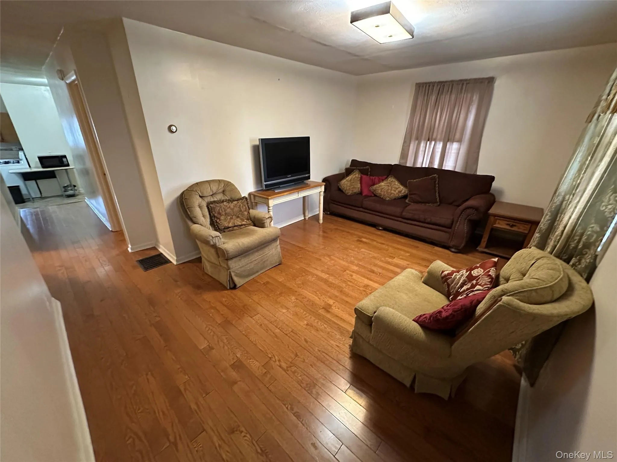 Furnished living room featuring baseboards and wood-type flooring Furnished living room featuring baseboards and wood-type flooring
