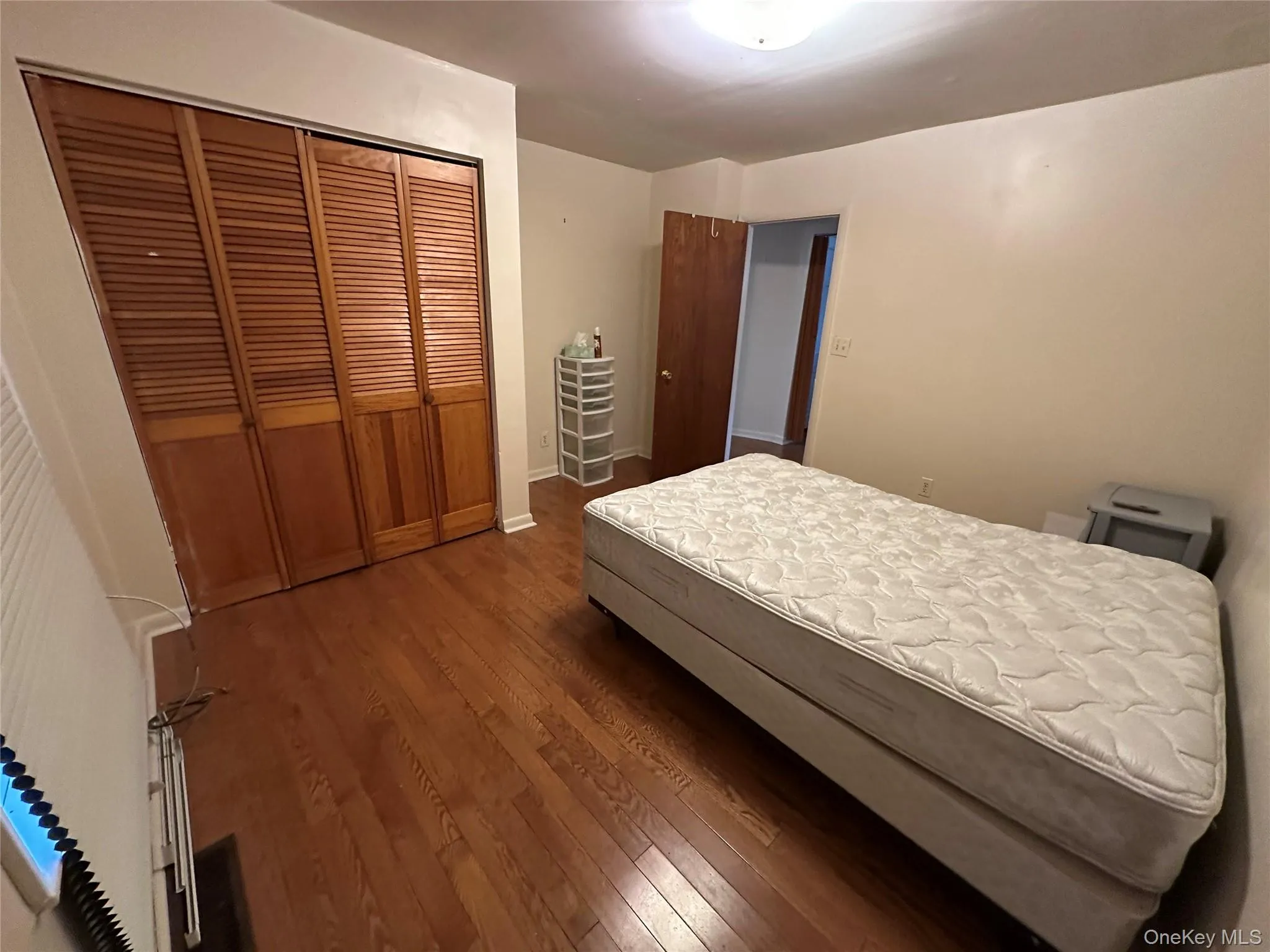 Bedroom featuring a closet, baseboards, and dark wood-style floors Bedroom featuring a closet, baseboards, and dark wood-style floors