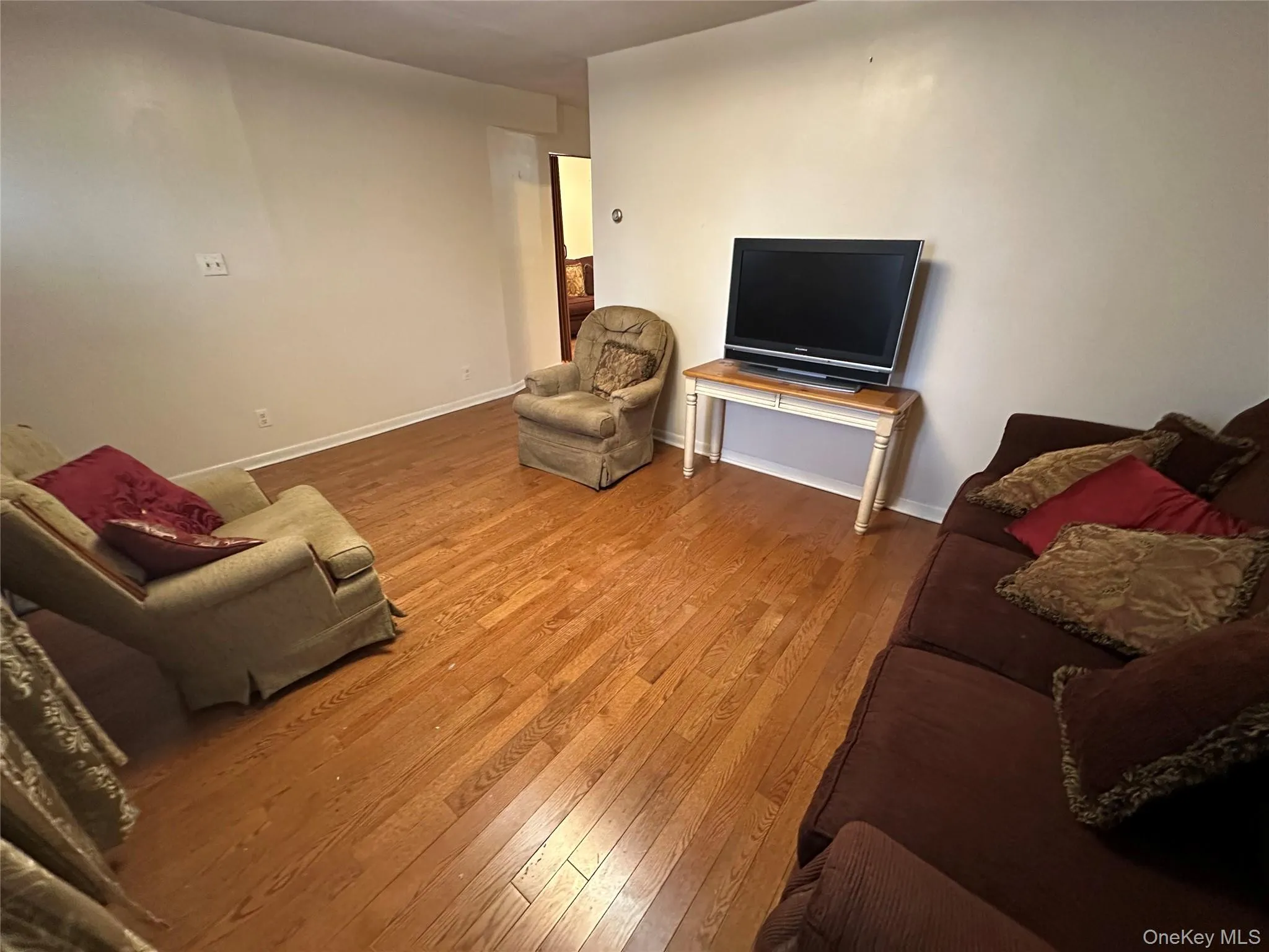 Living room featuring baseboards and wood-type flooring Living room featuring baseboards and wood-type flooring