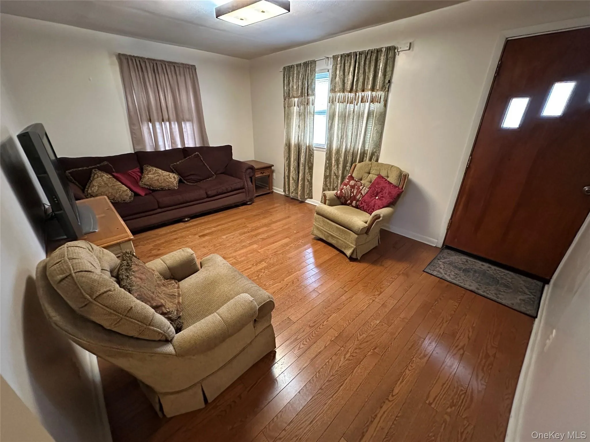 Living room featuring hardwood / wood-style flooring and baseboards Living room featuring hardwood / wood-style flooring and baseboards