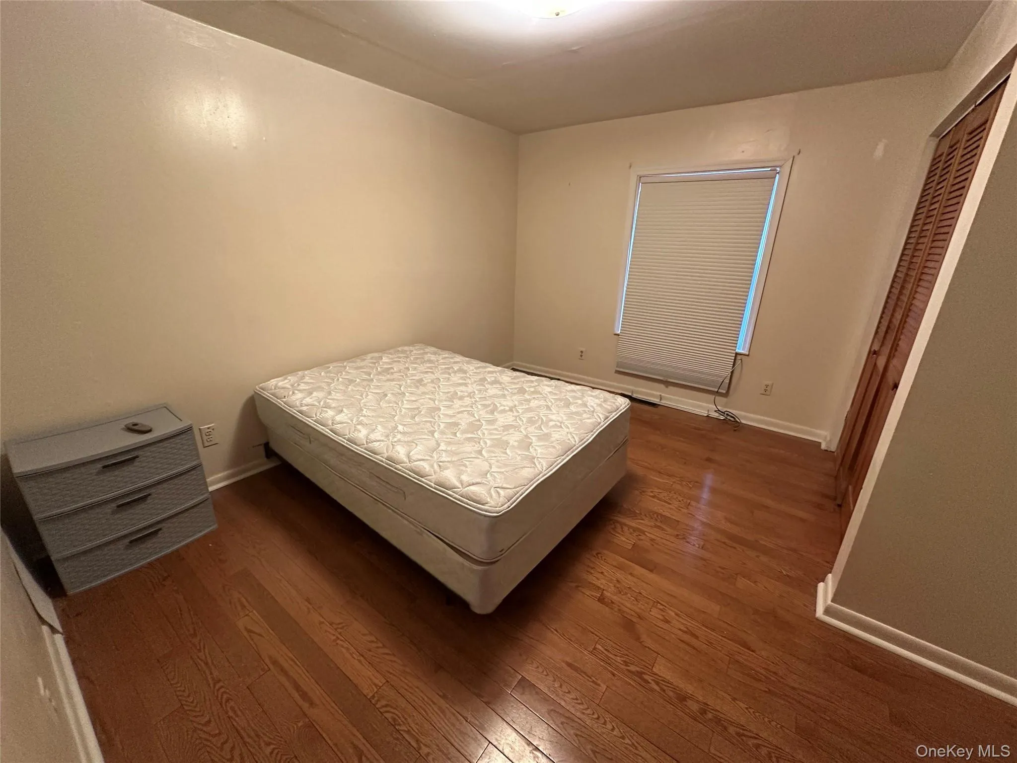 Bedroom with a closet, baseboards, and wood finished floors Bedroom with a closet, baseboards, and wood finished floors