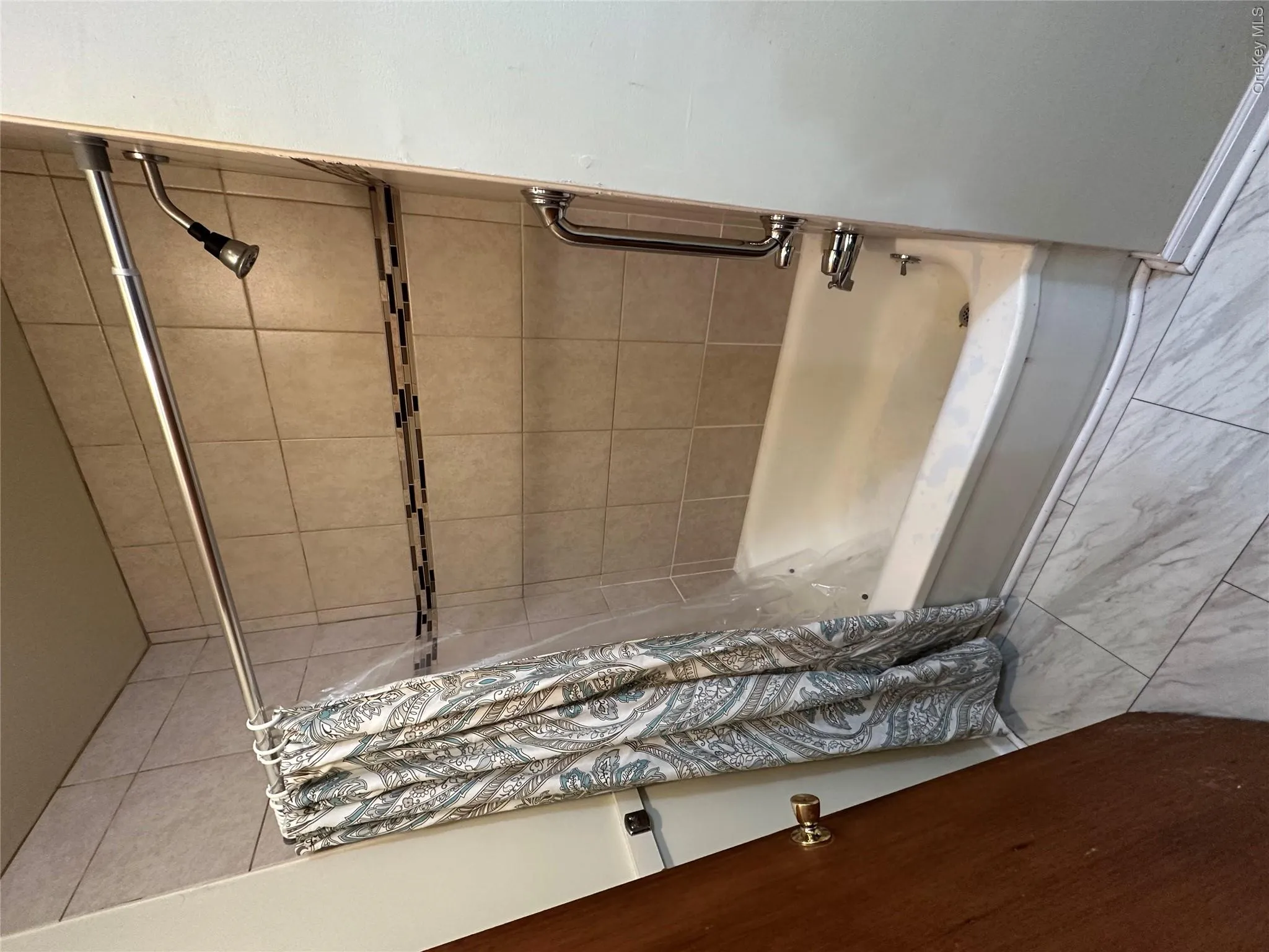 Full bath featuring shower / bath combo with shower curtain and marble finish floor Full bath featuring shower / bath combo with shower curtain and marble finish floor