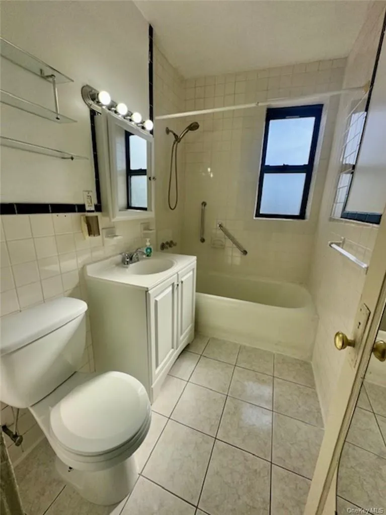 Full bathroom featuring a wealth of natural light, vanity, and toilet Full bathroom featuring a wealth of natural light, vanity, and toilet