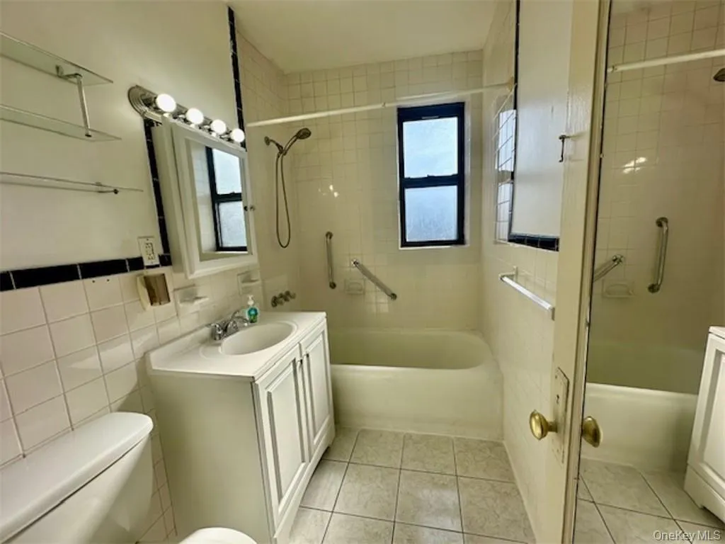 Full bathroom featuring tile patterned flooring, vanity, toilet, and tiled shower / bath Full bathroom featuring tile patterned flooring, vanity, toilet, and tiled shower / bath