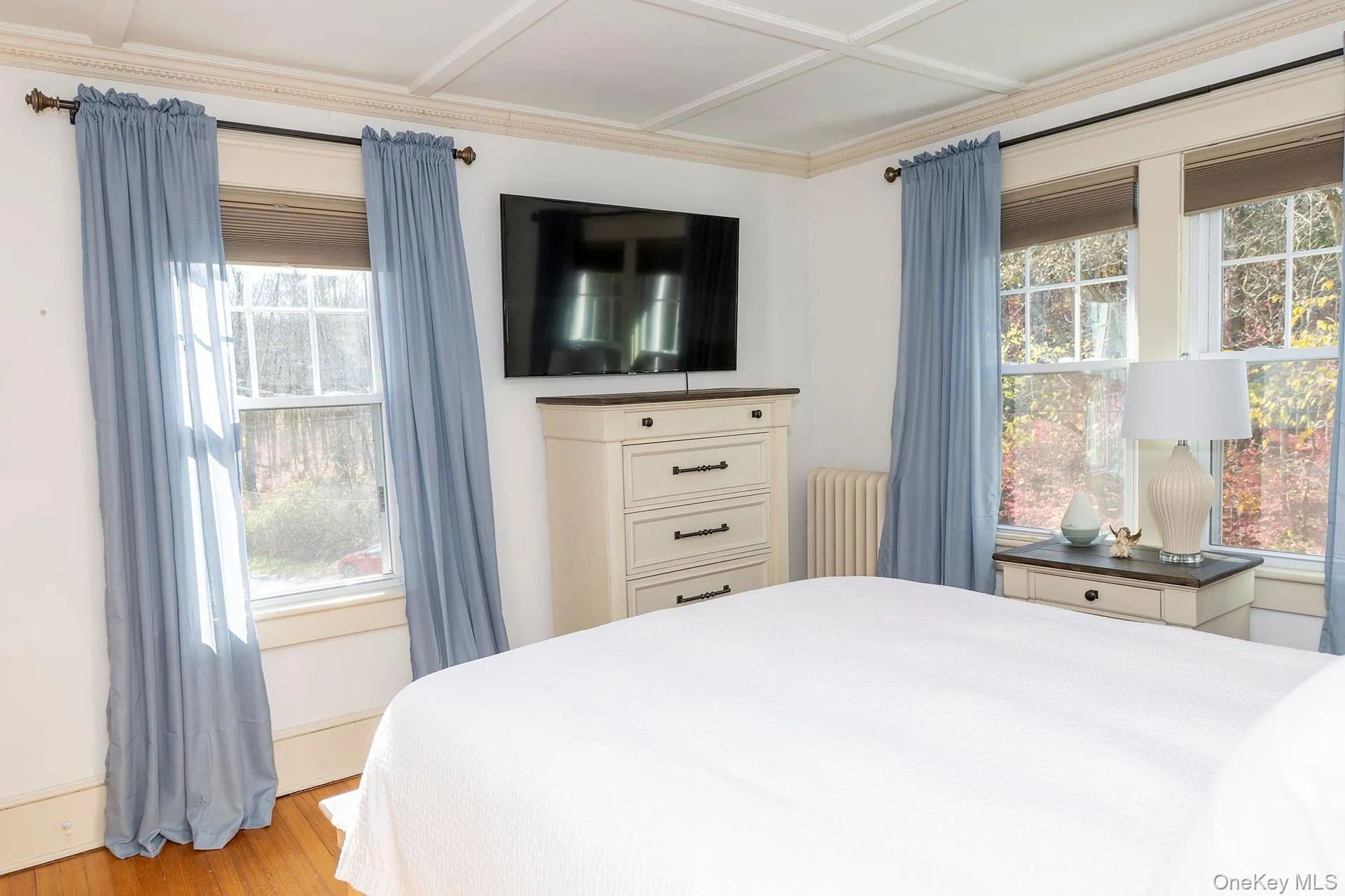 Bedroom featuring radiator heating unit and wood finished floors Bedroom featuring radiator heating unit and wood finished floors