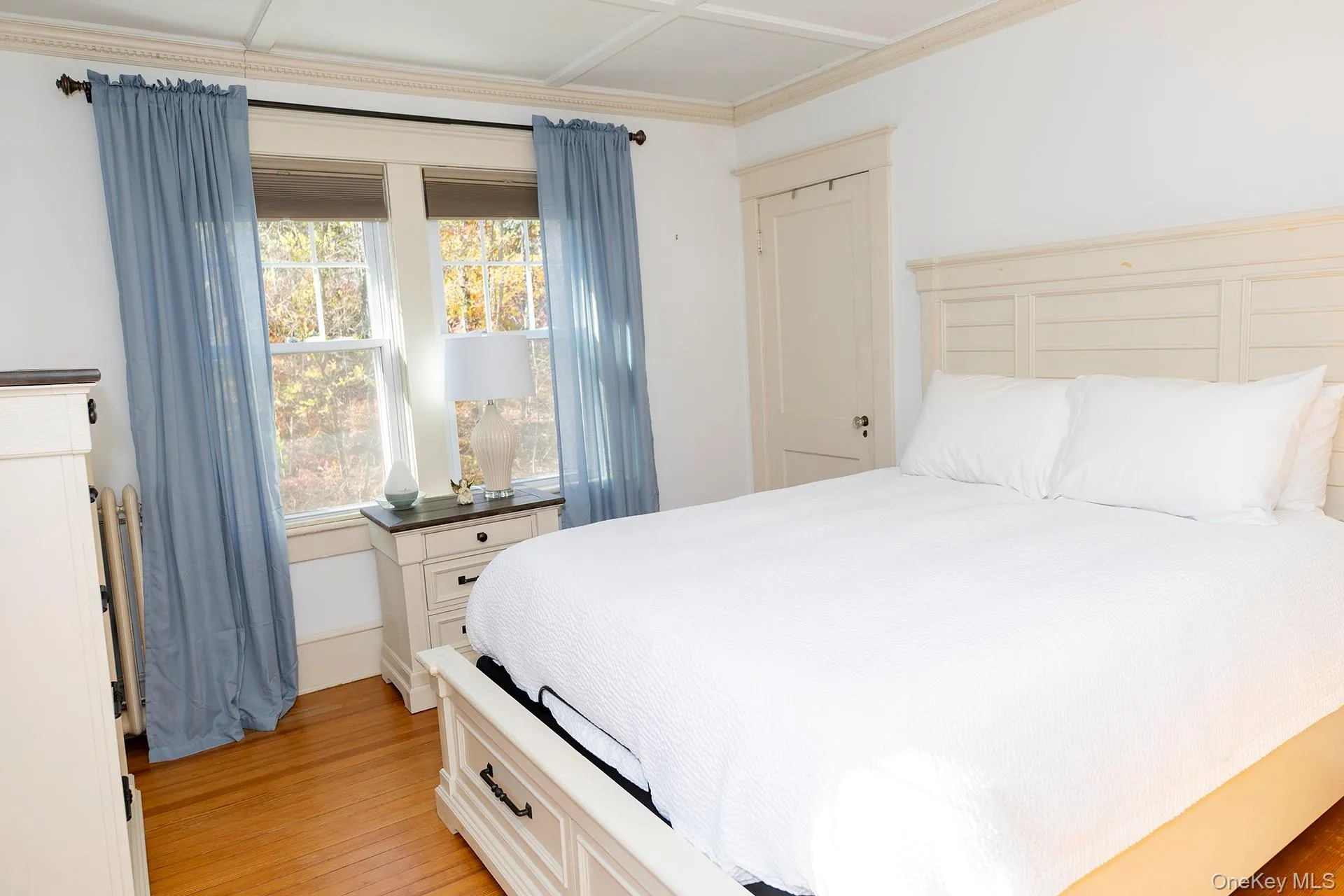 Bedroom featuring light wood-type flooring and crown molding Bedroom featuring light wood-type flooring and crown molding