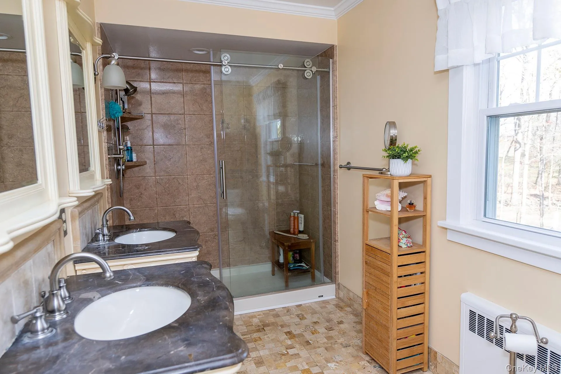 Full bath featuring radiator heating unit, vanity, a stall shower, and crown molding Full bath featuring radiator heating unit, vanity, a stall shower, and crown molding